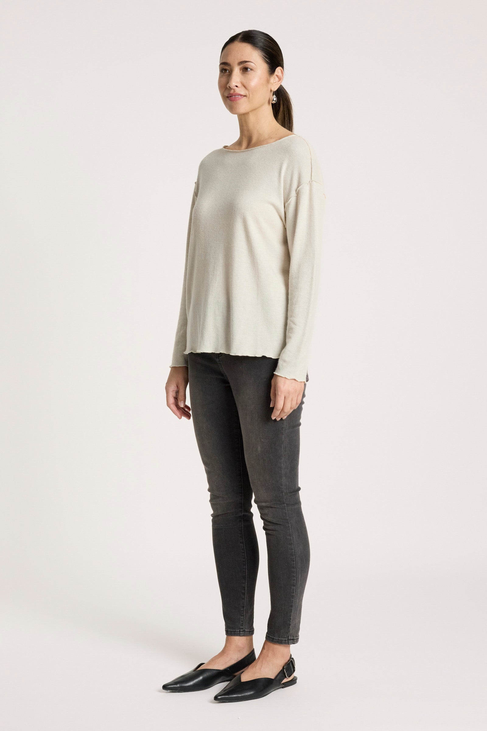 Image of Woman wearing a Eb & Ive beige sweater and black pants on a white background