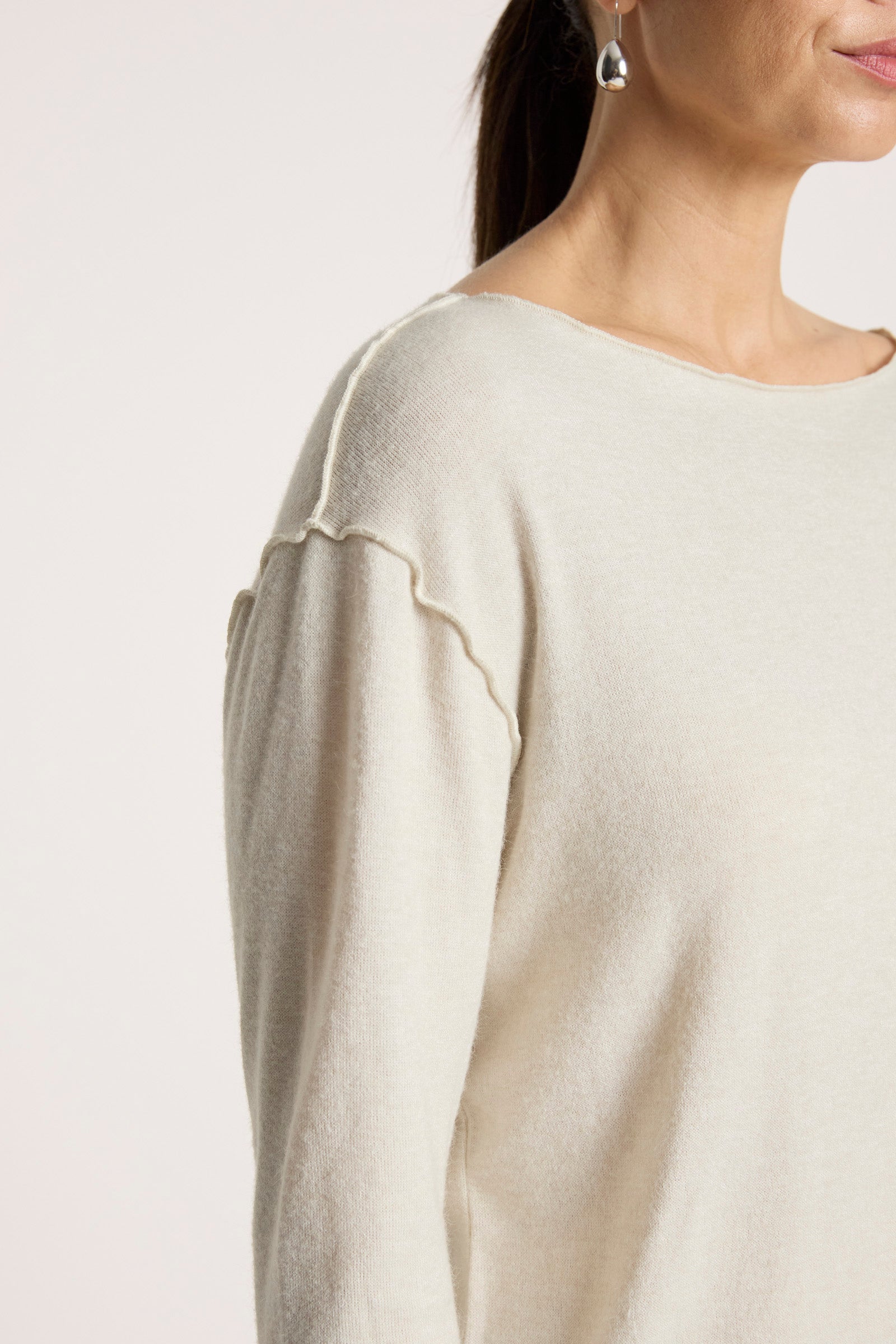 Close-up of a Woman wearing a Eb & Ive light-colored sweater on a plain background