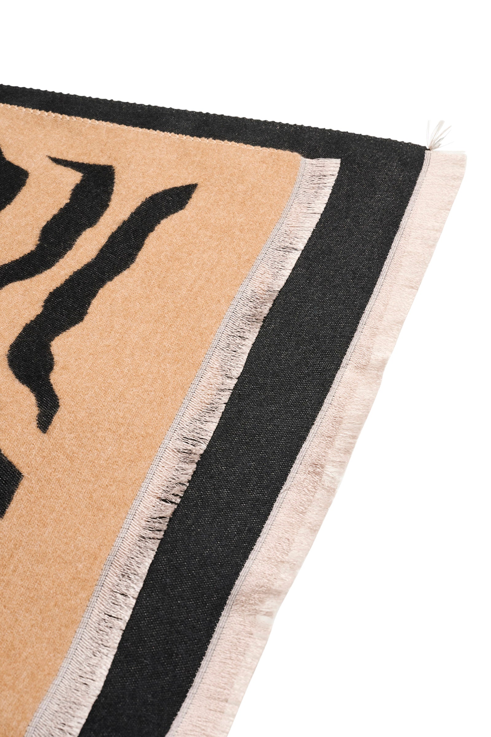 Close-up of a Eb & Ive scarf with black abstract design and beige border on a white background