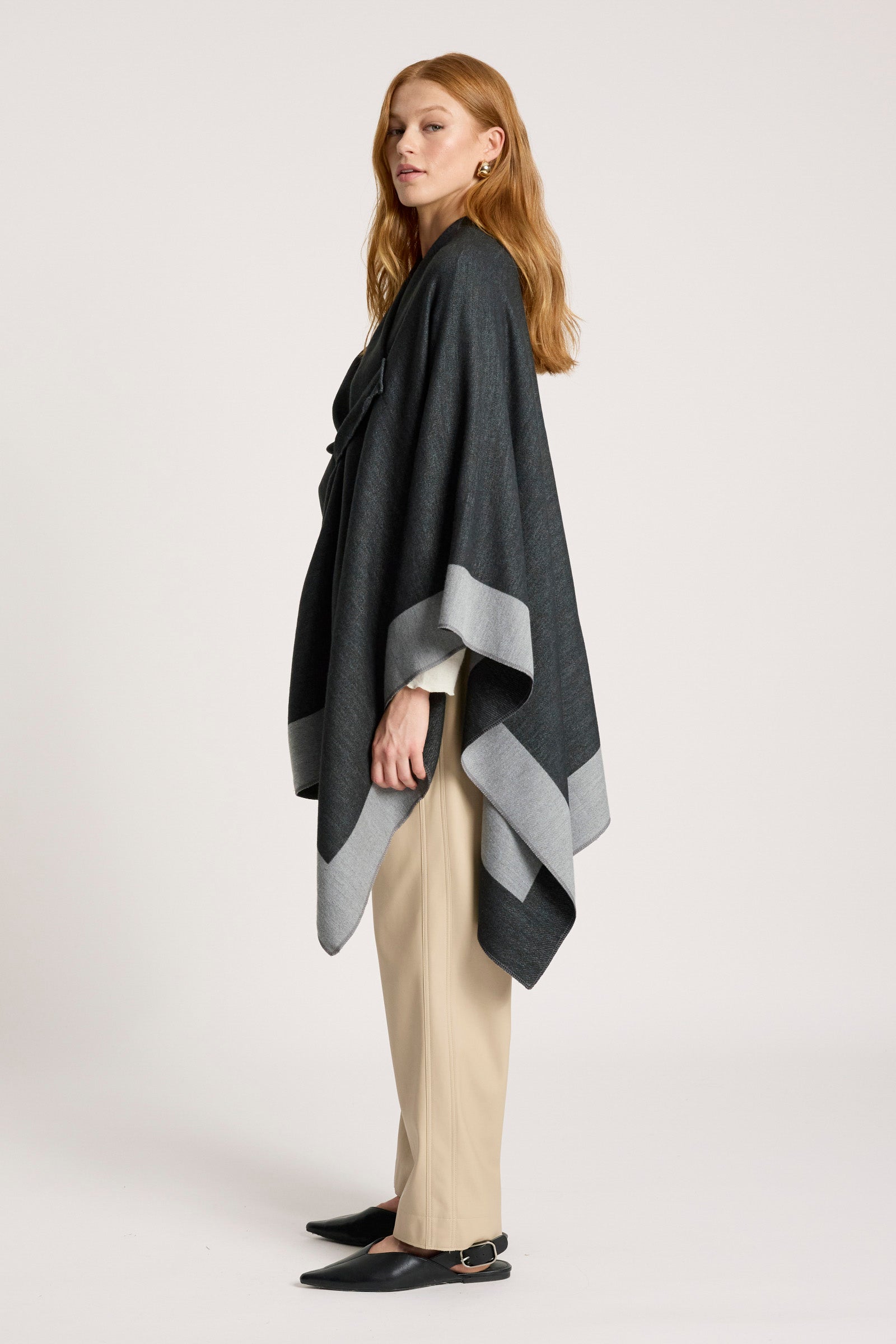 Woman wearing a Eb & Ive dark gray poncho with a light gray stripe on a white background