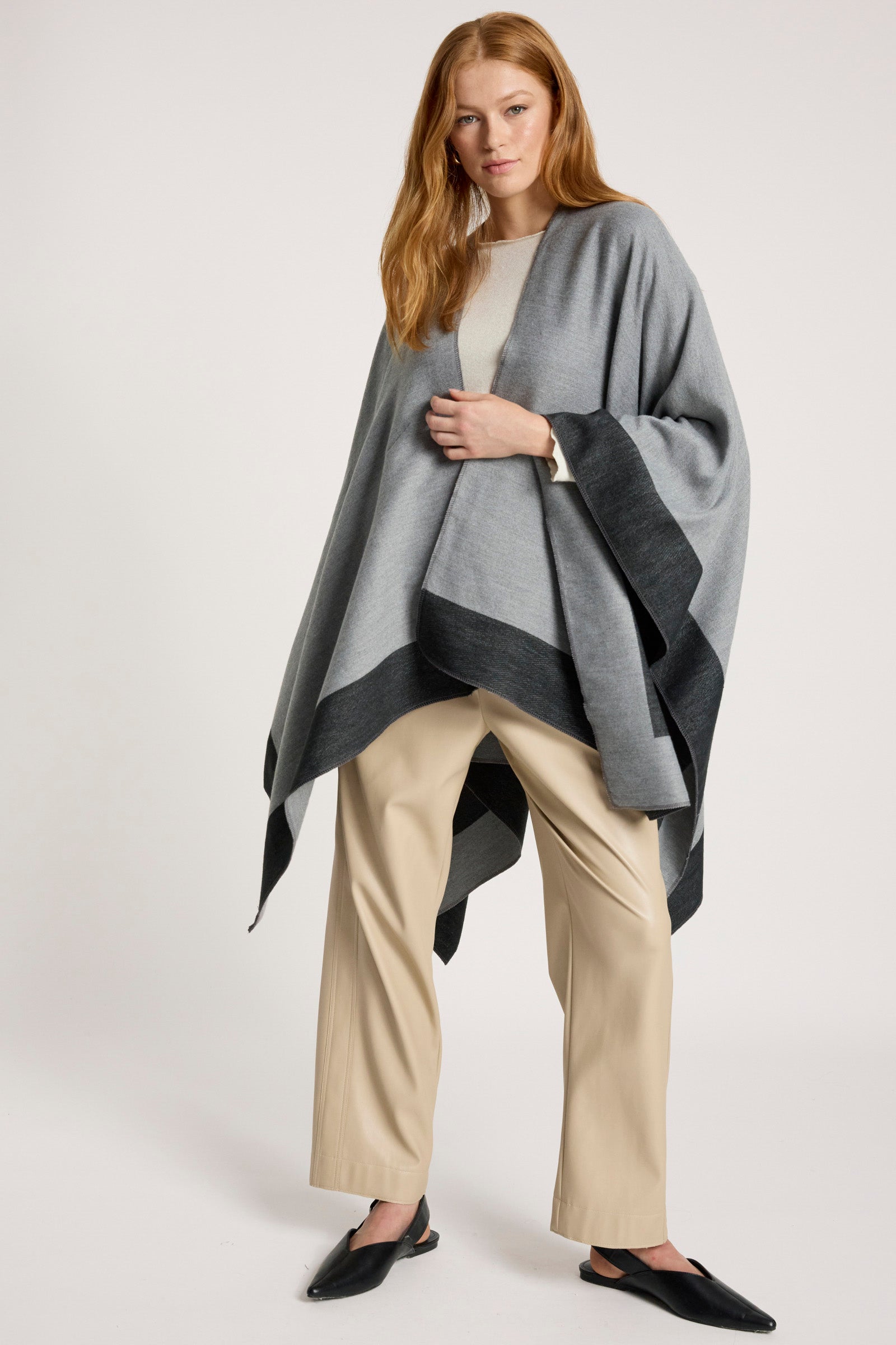 Image of Woman wearing a Eb & Ive gray poncho over a beige outfit on a white background