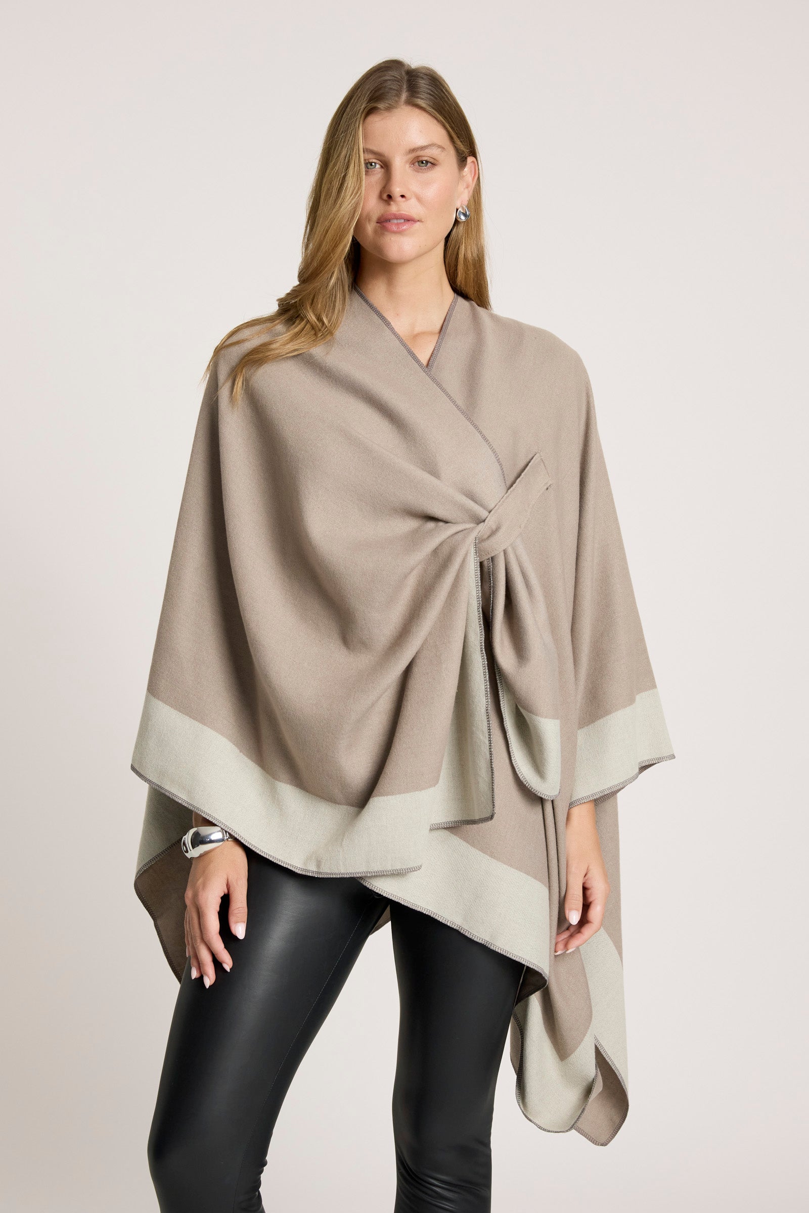Image of Woman wearing a Eb & Ive beige wrap over a plain background