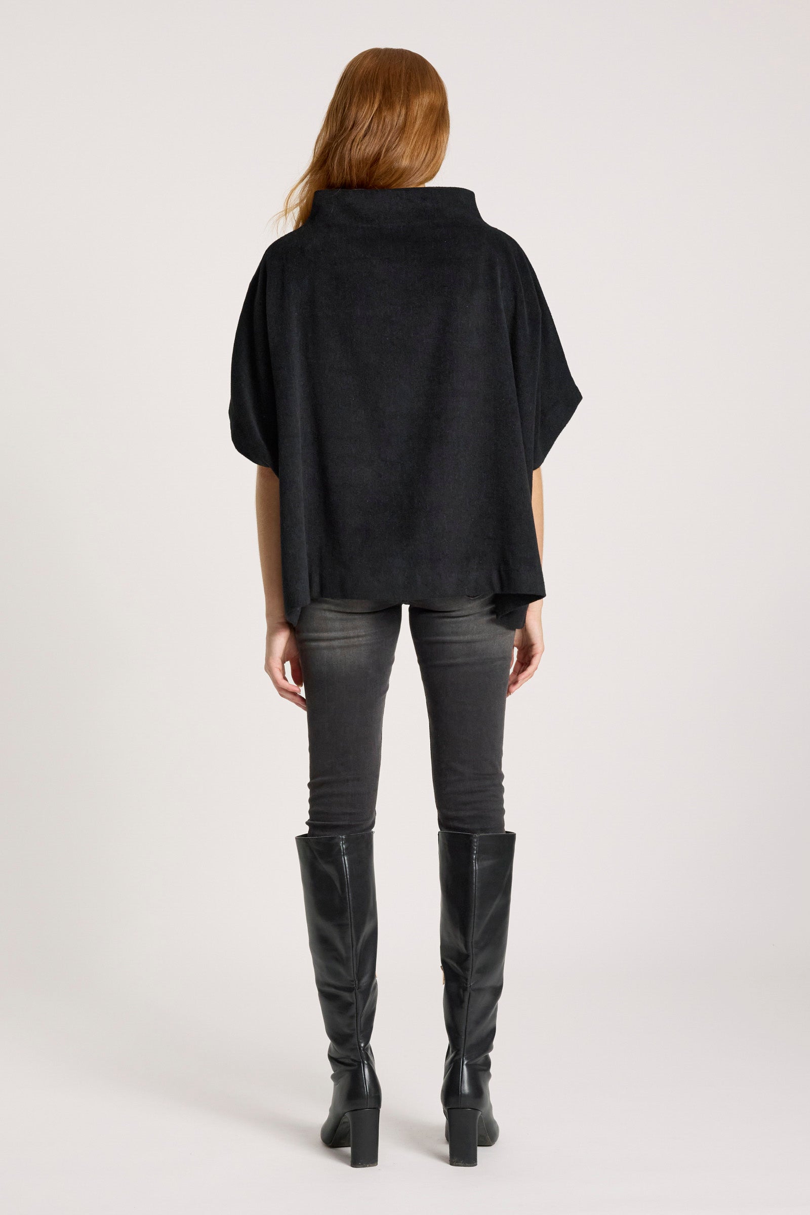 Image of Person wearing a Eb & Ive black poncho, gray pants, and black knee-high boots on a white background