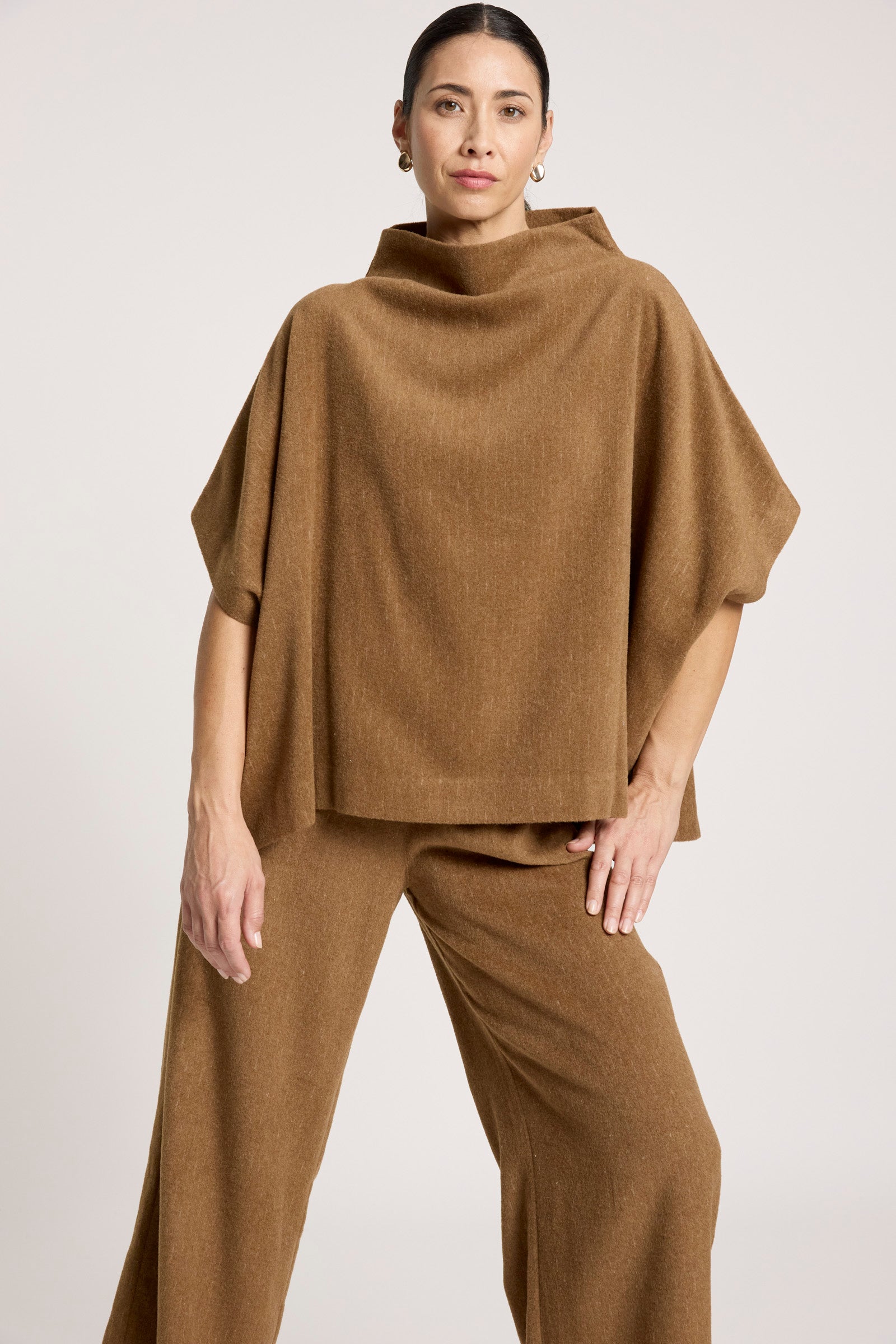 Woman wearing a Eb & Ive brown poncho and pants on a white background