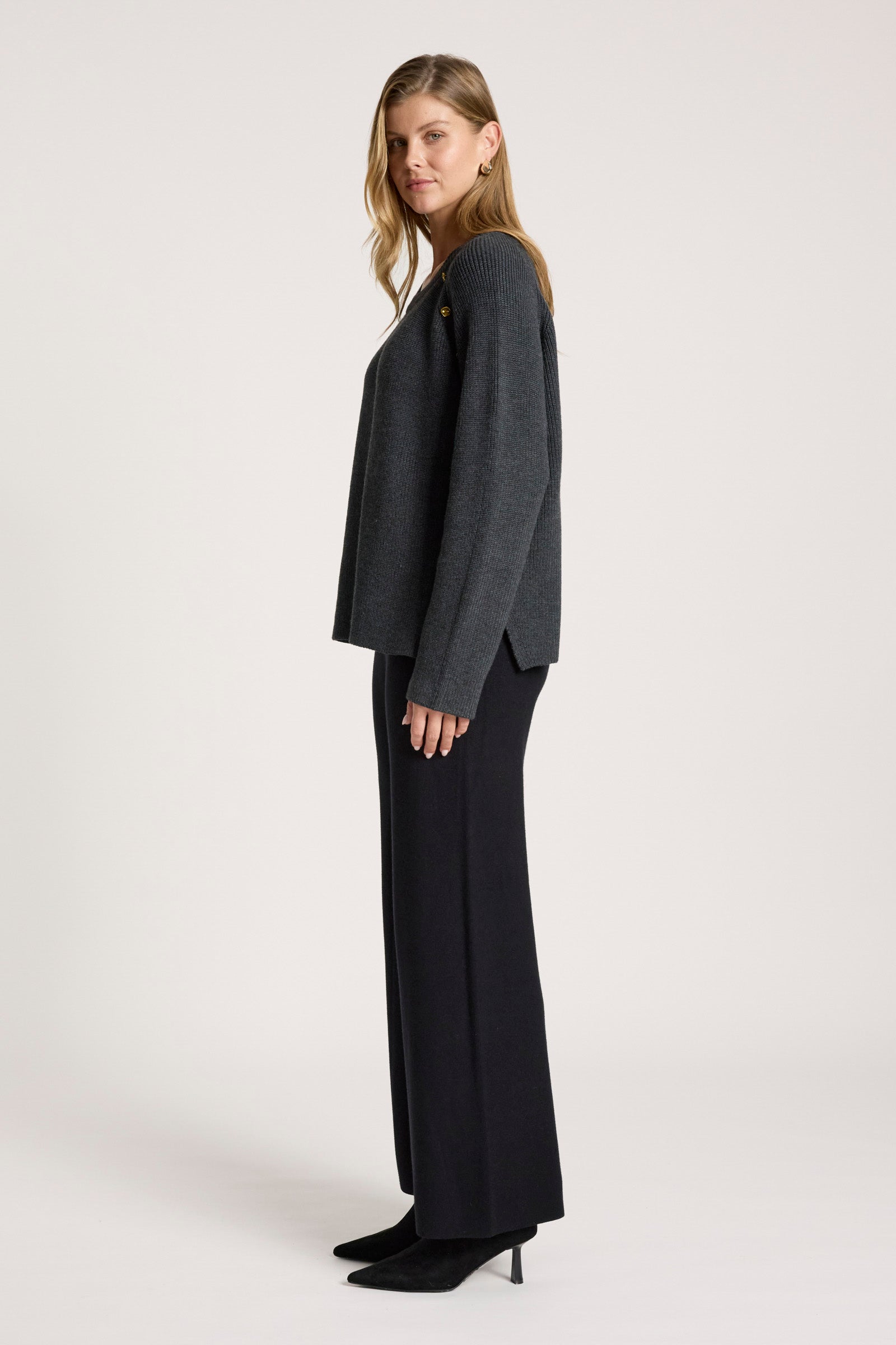 Woman wearing a Eb & Ive dark grey jumper on a white background