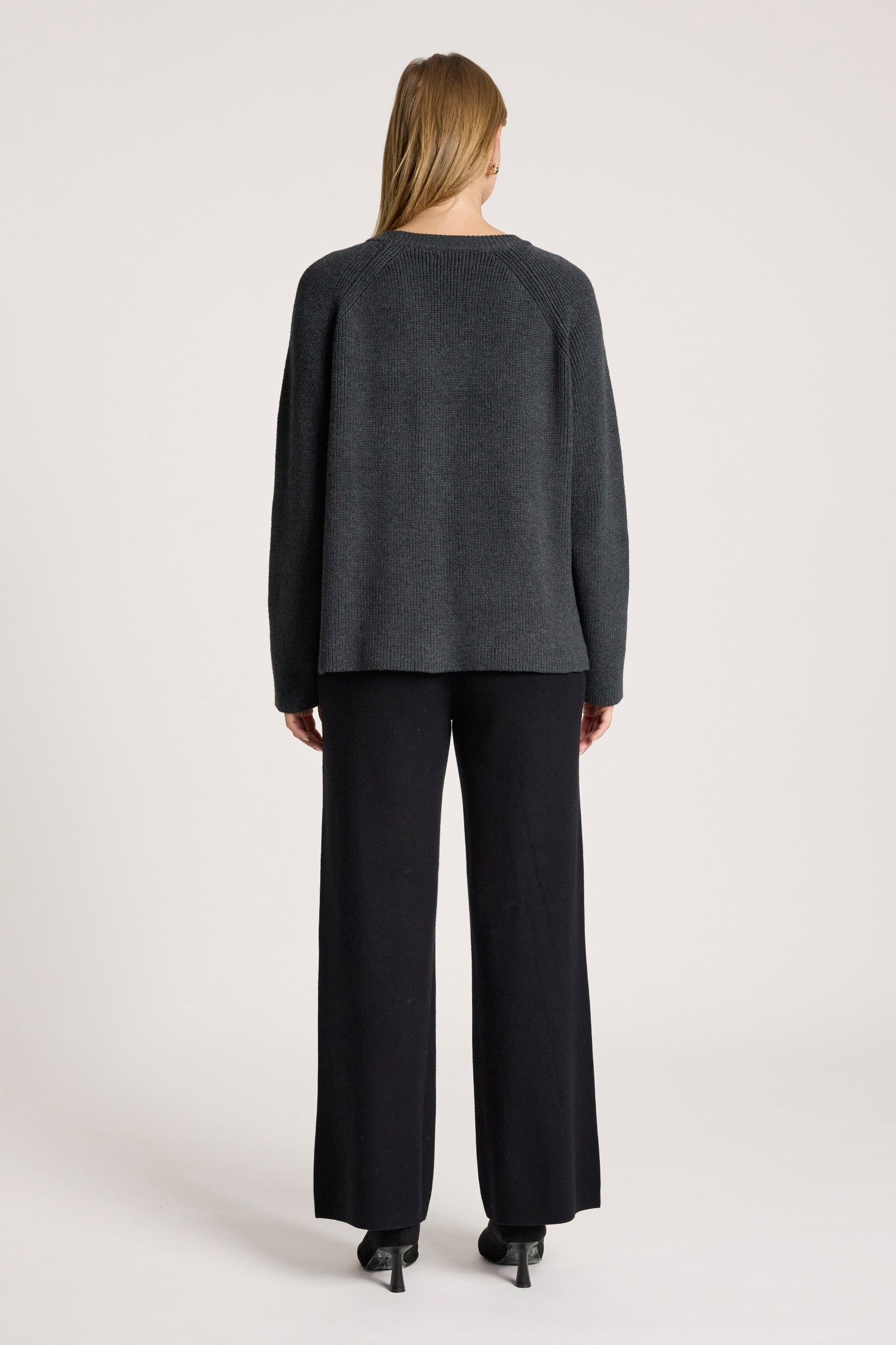 Image of Women wearing a Eb & Ive grey sweater and black pants on a white background