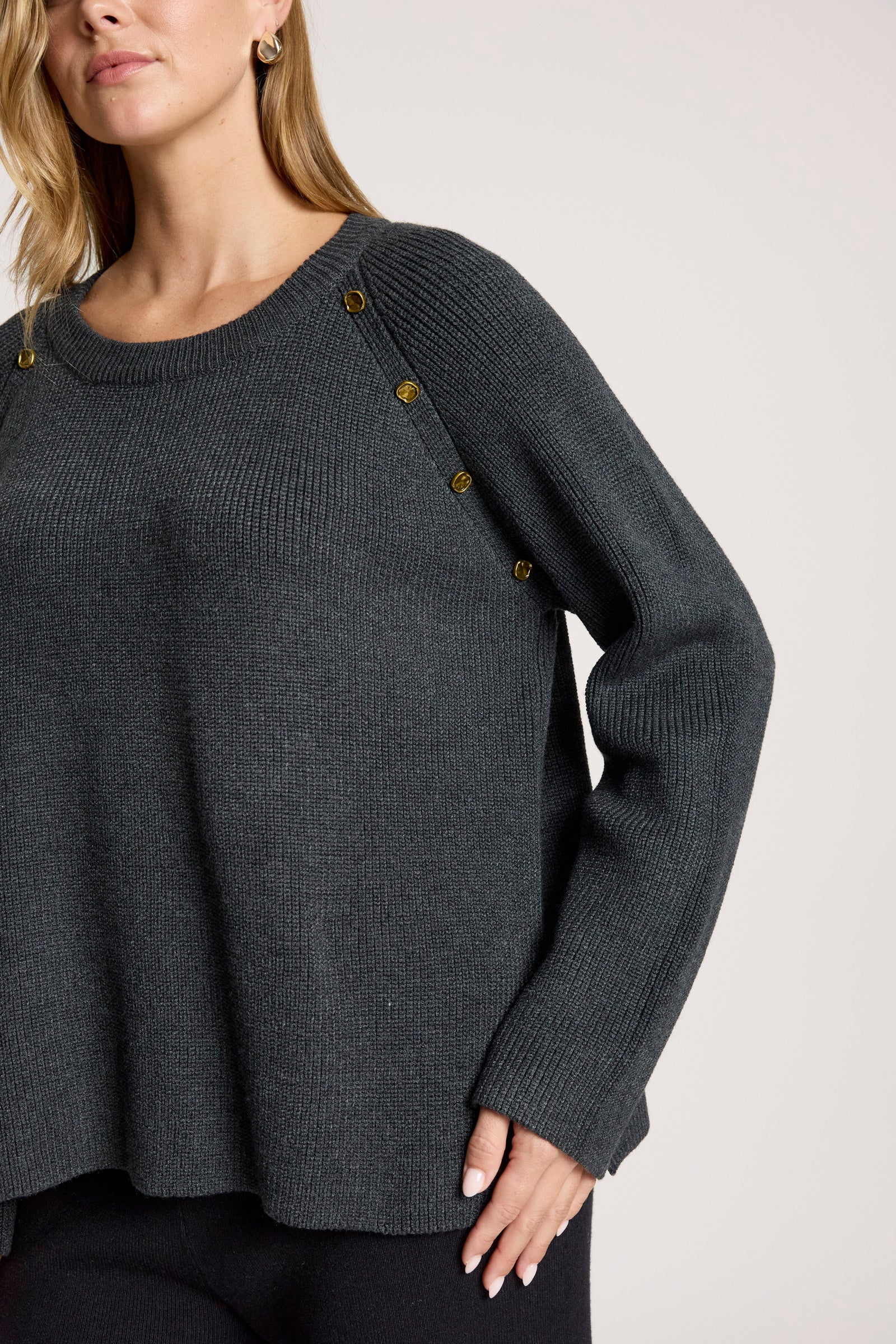 Image of Woman wearing Eb & Ive dark grey sweater with button details on a plain background