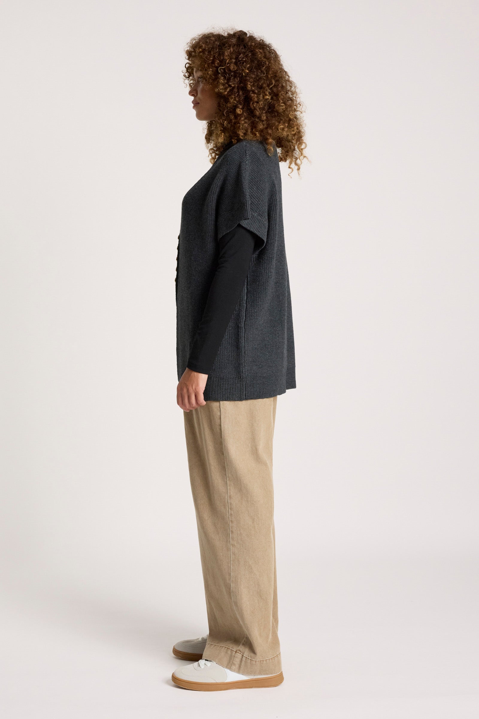 Image of Woman wearing a Eb & Ive dark grey sweater and beige pants on a white background