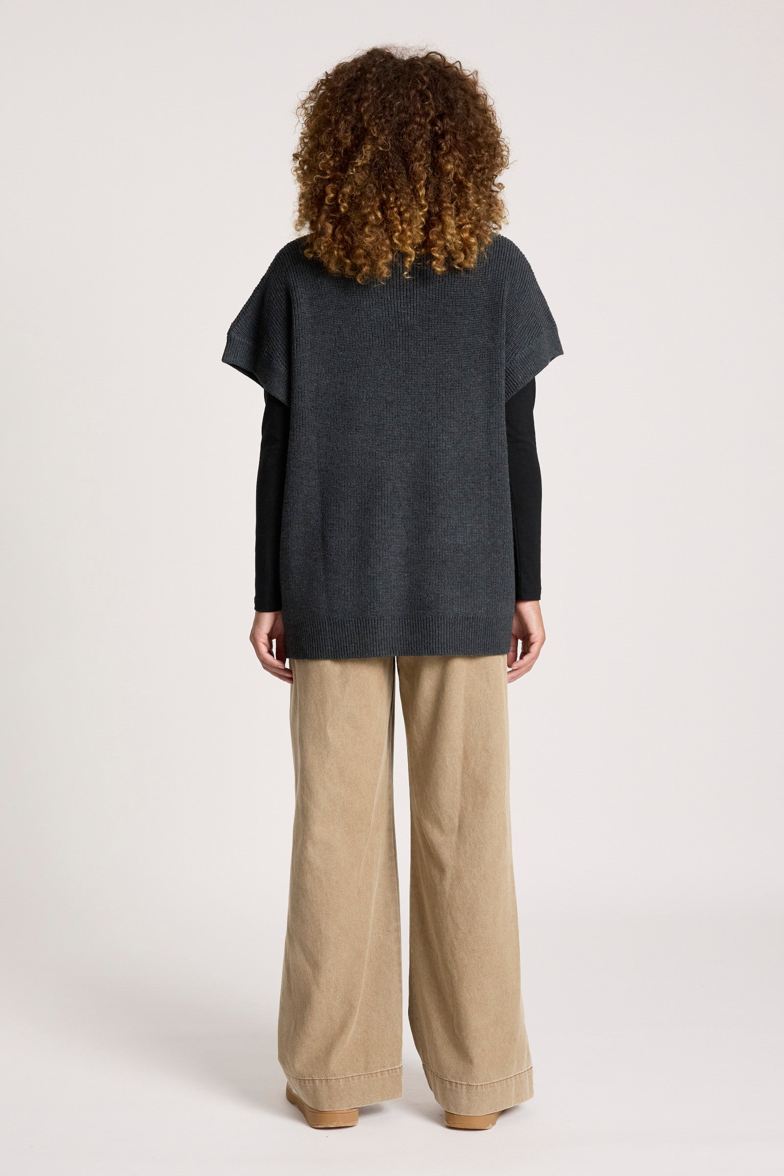 Image of Woman wearing a Eb & Ive dark grey top and beige pants on a white background