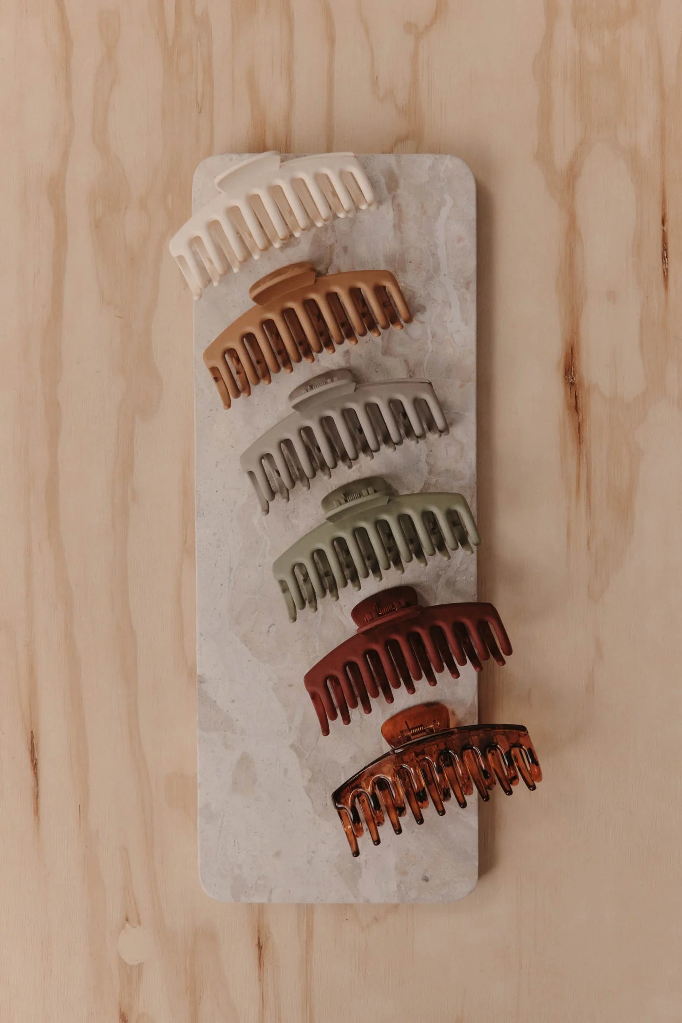 Image of Set of Eb & Ive hair claw clips on a stone block against a wooden background