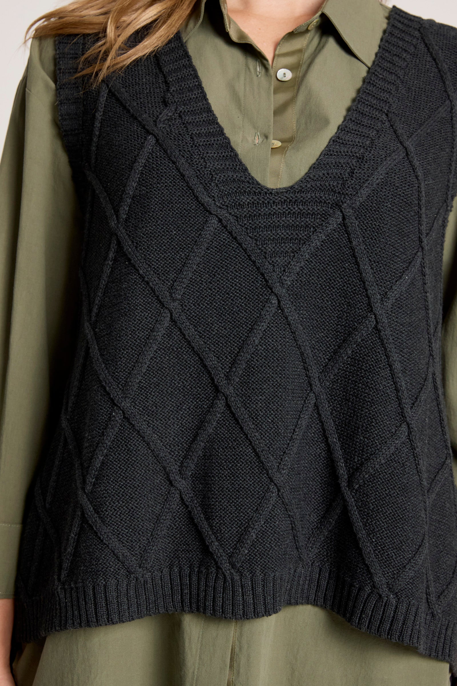 Eb and Ive Dark gray knitted vest worn over a green shirt