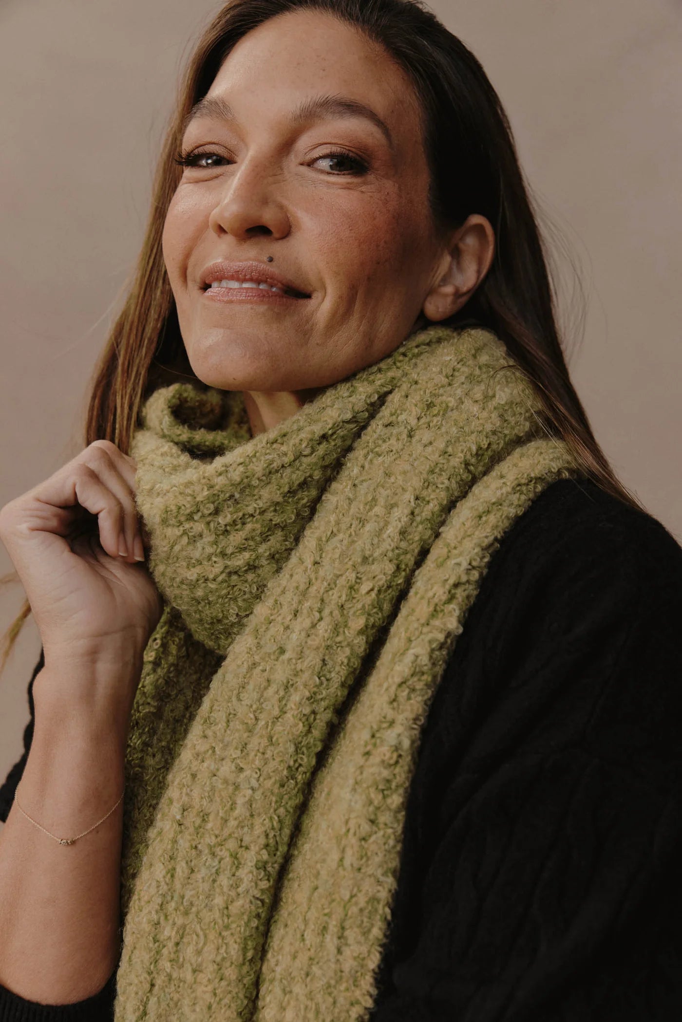 Woman wearing a Eb & Ive green scarf against a neutral background
