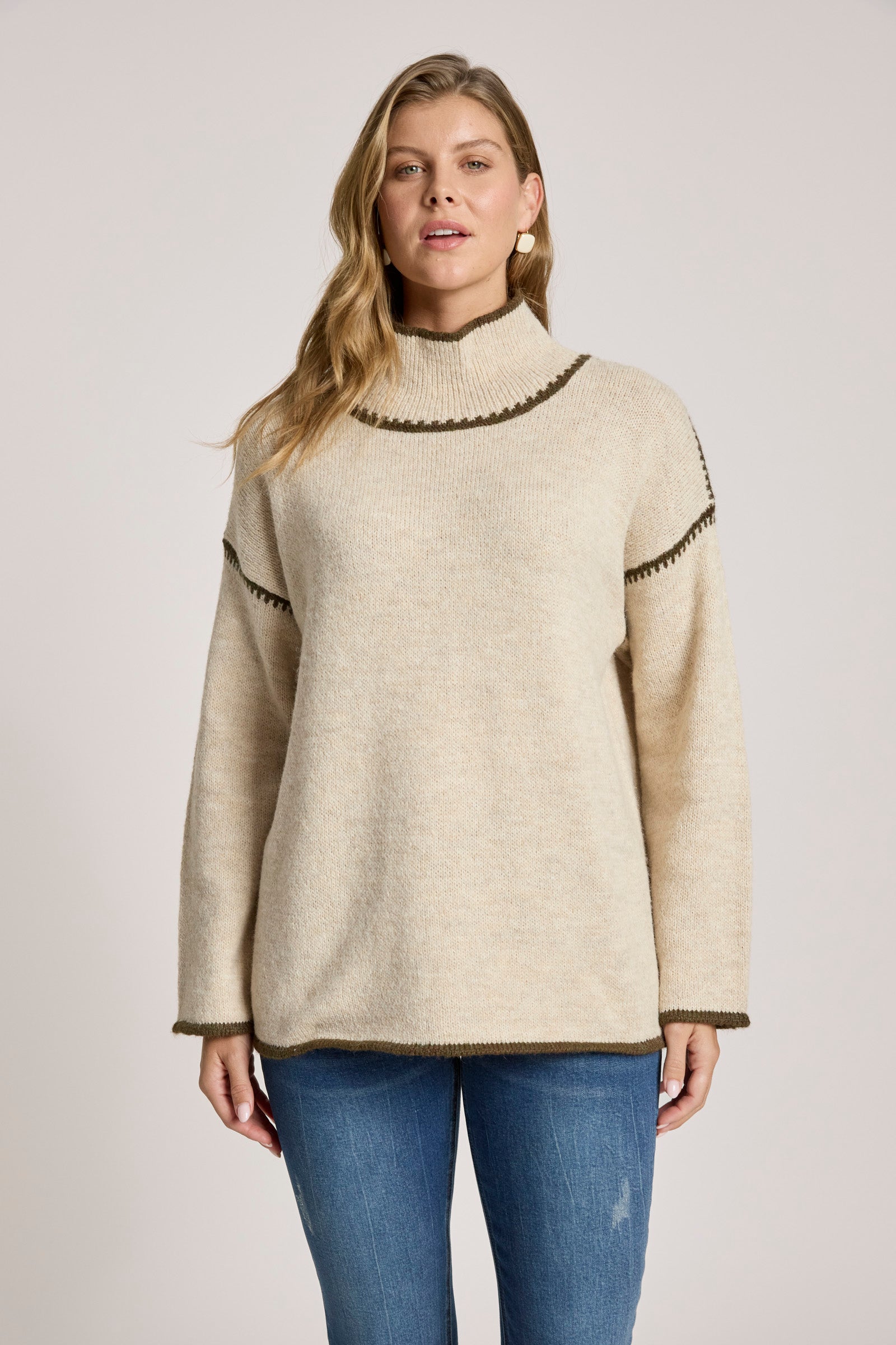 Woman wearing a Eb & Ive beige sweater with black trim on a plain background