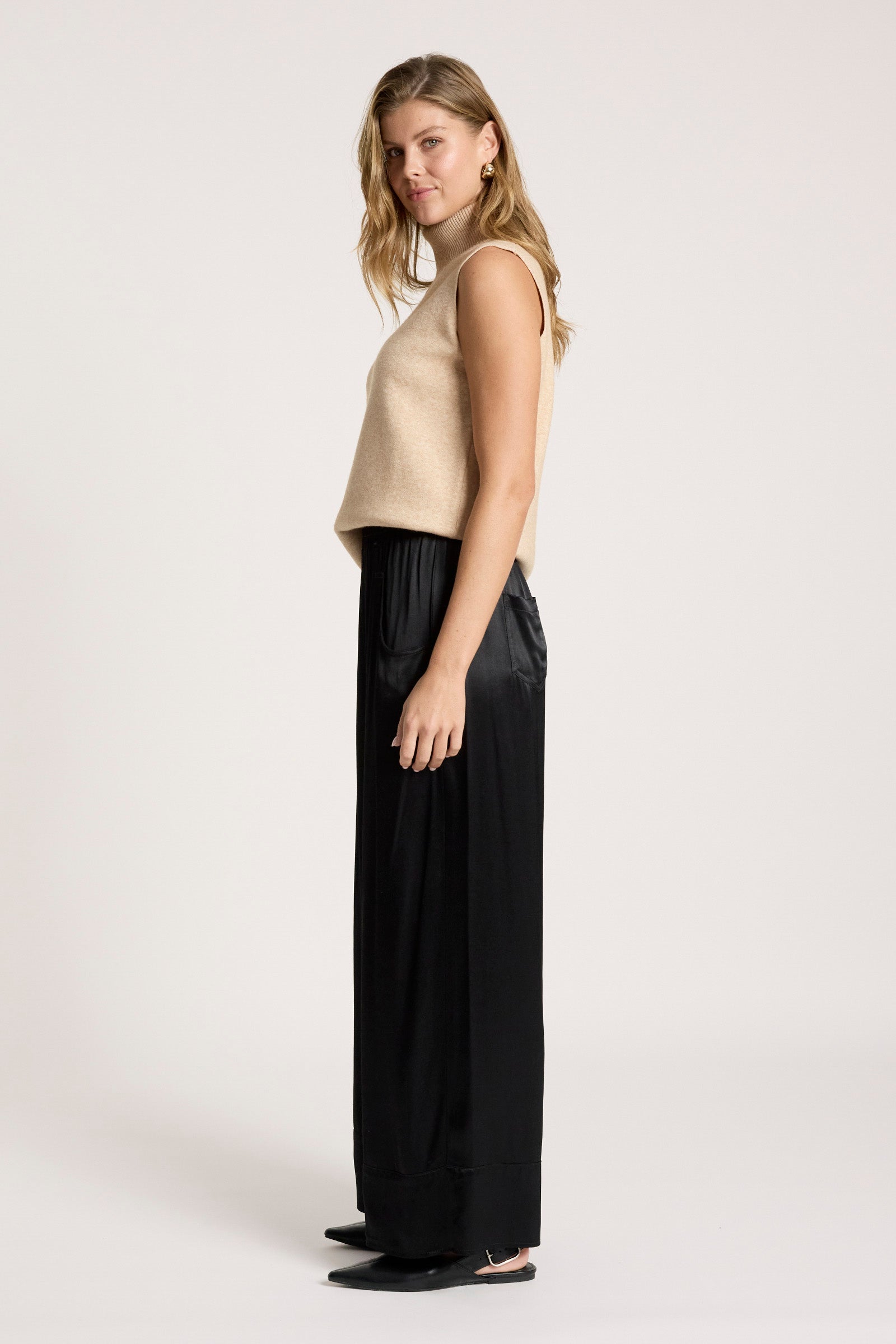 Woman wearing a beige sleeveless top and Eb & Ive black wide-leg pants on a white background 