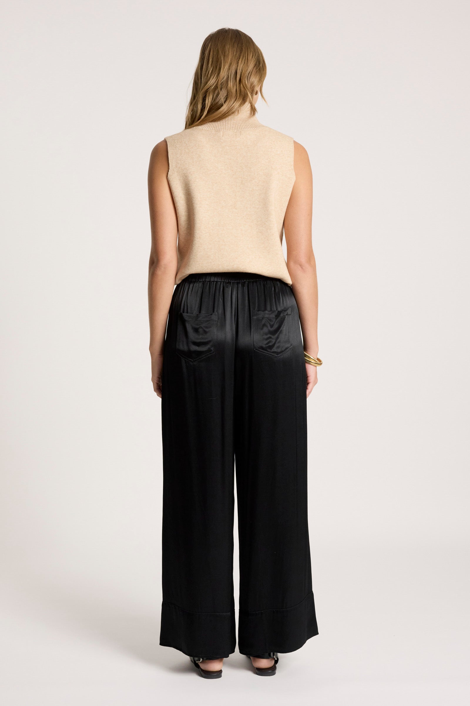 Image of Woman wearing a beige sleeveless top and Eb & Ive black wide-leg pants on a white background