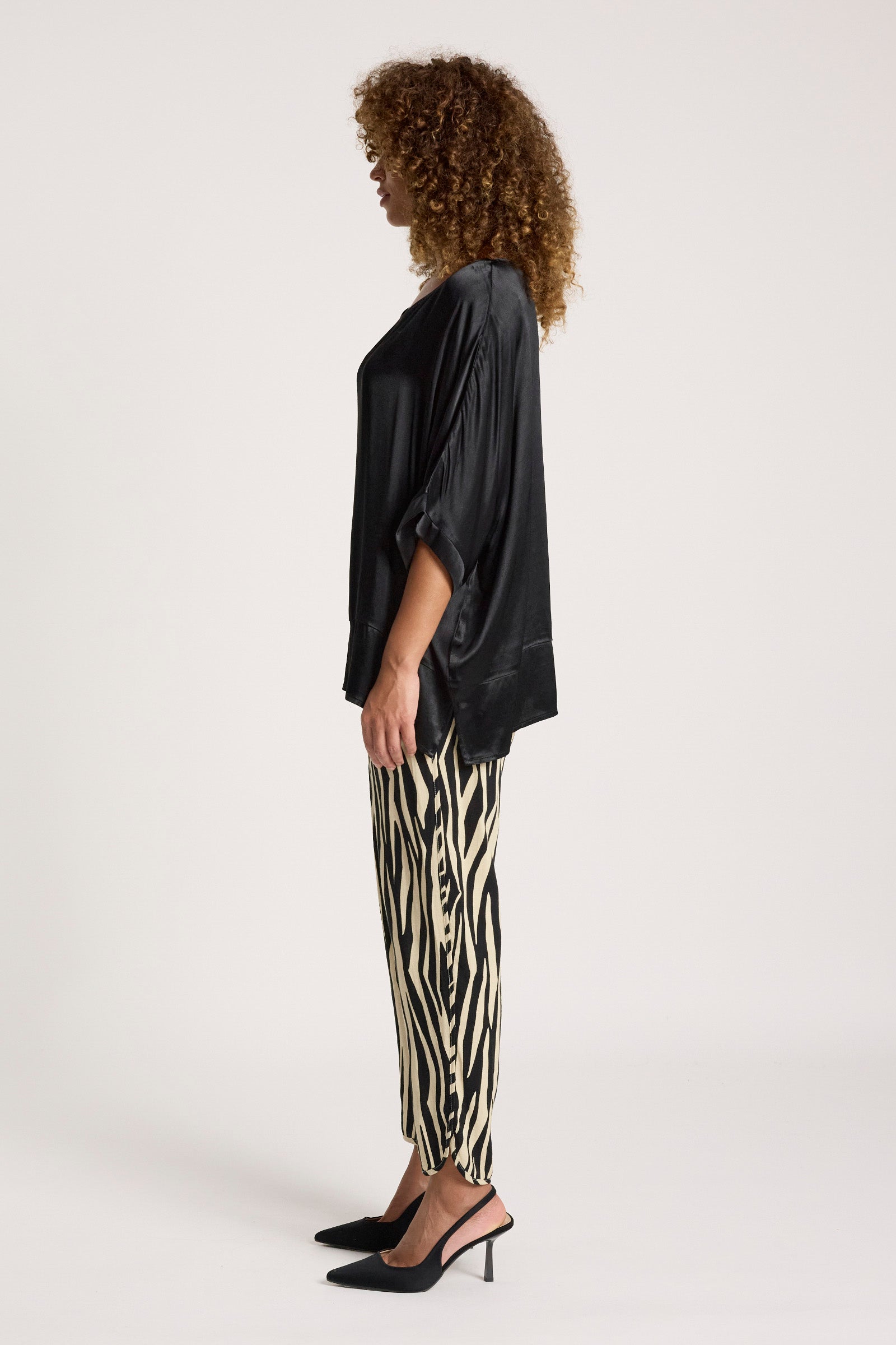Image of Person wearing a Eb & Ive black top and zebra print pants on a white background