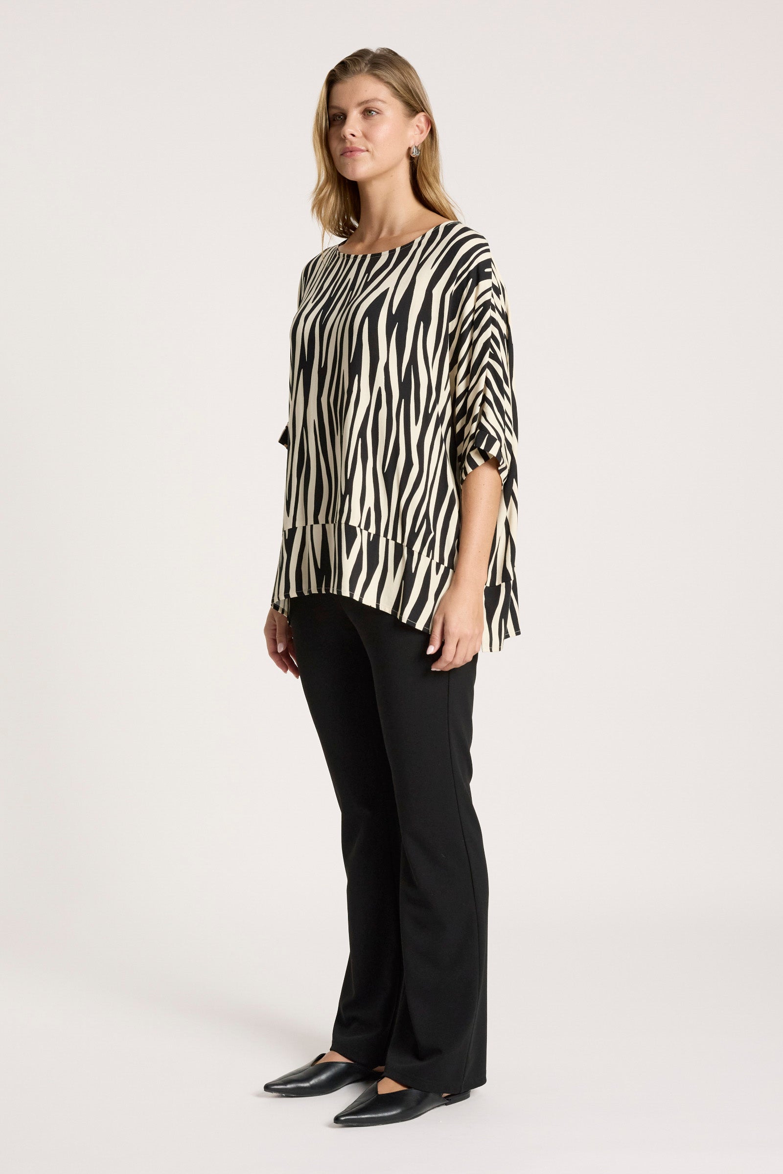 Image of Woman wearing a Eb & Ive zebra print blouse and black pants on a white background