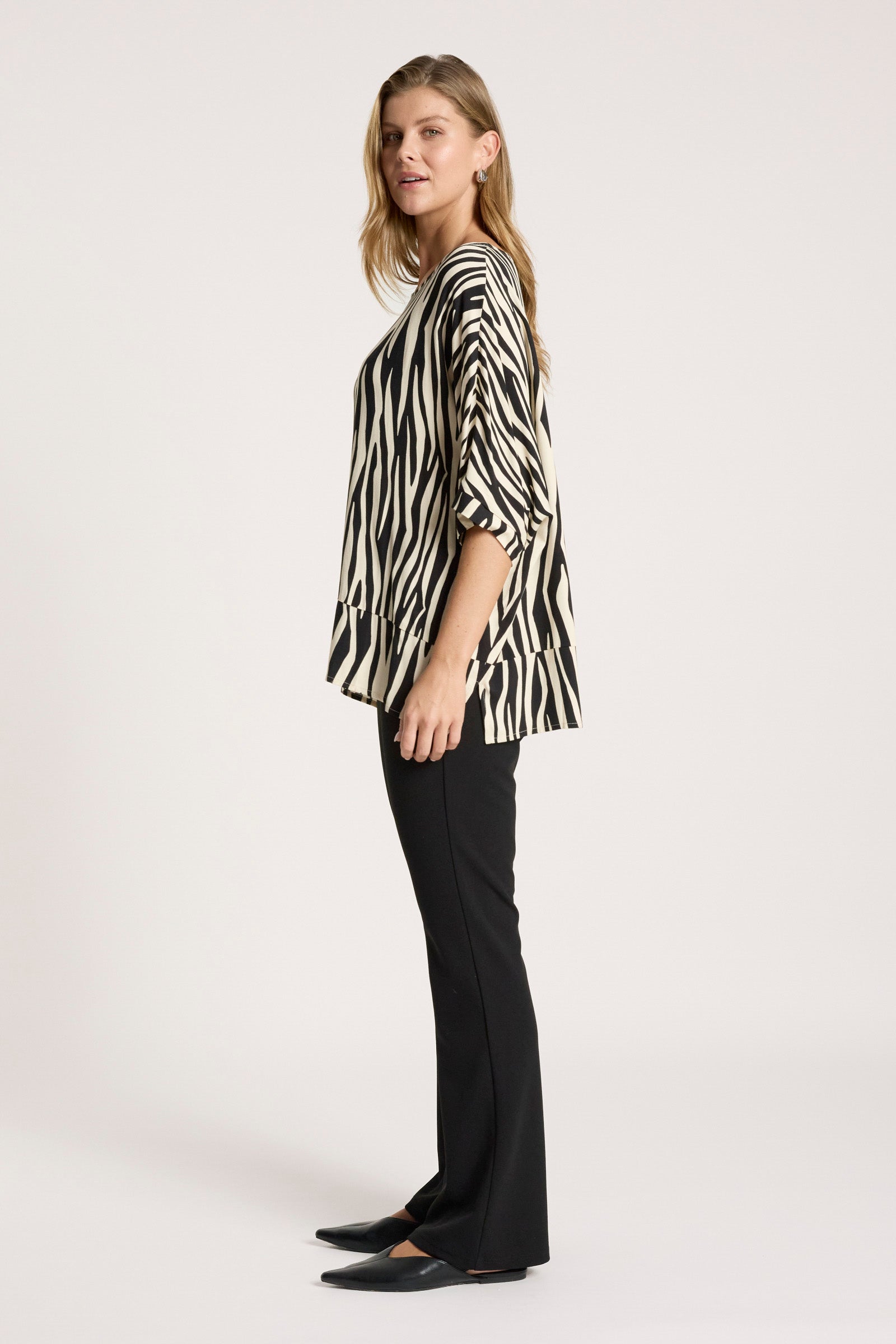Image of Woman wearing a Eb & Ive zebra print blouse and black pants on a white background