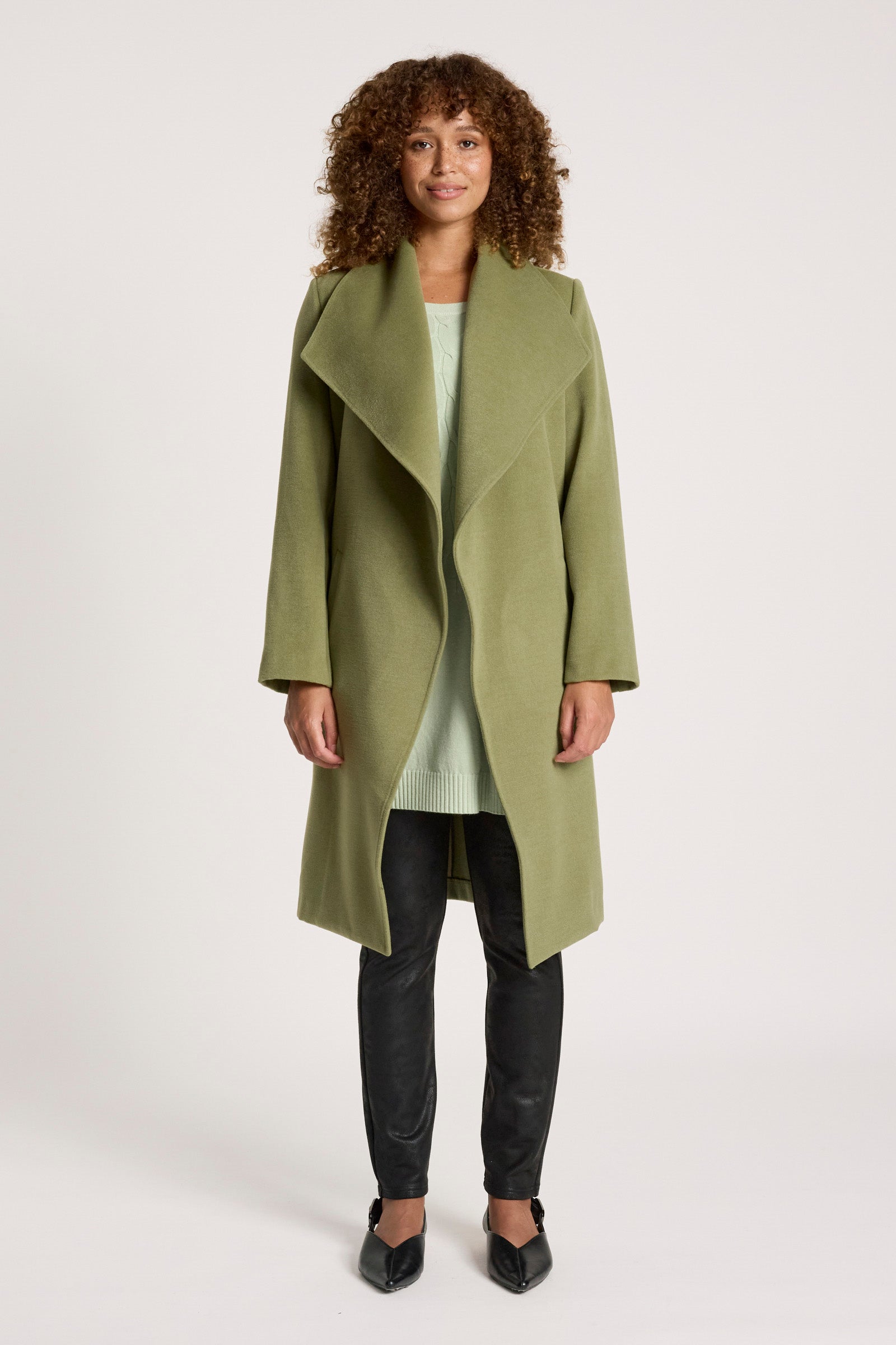 Image of Woman wearing a Eb & Ive green coat on a white background