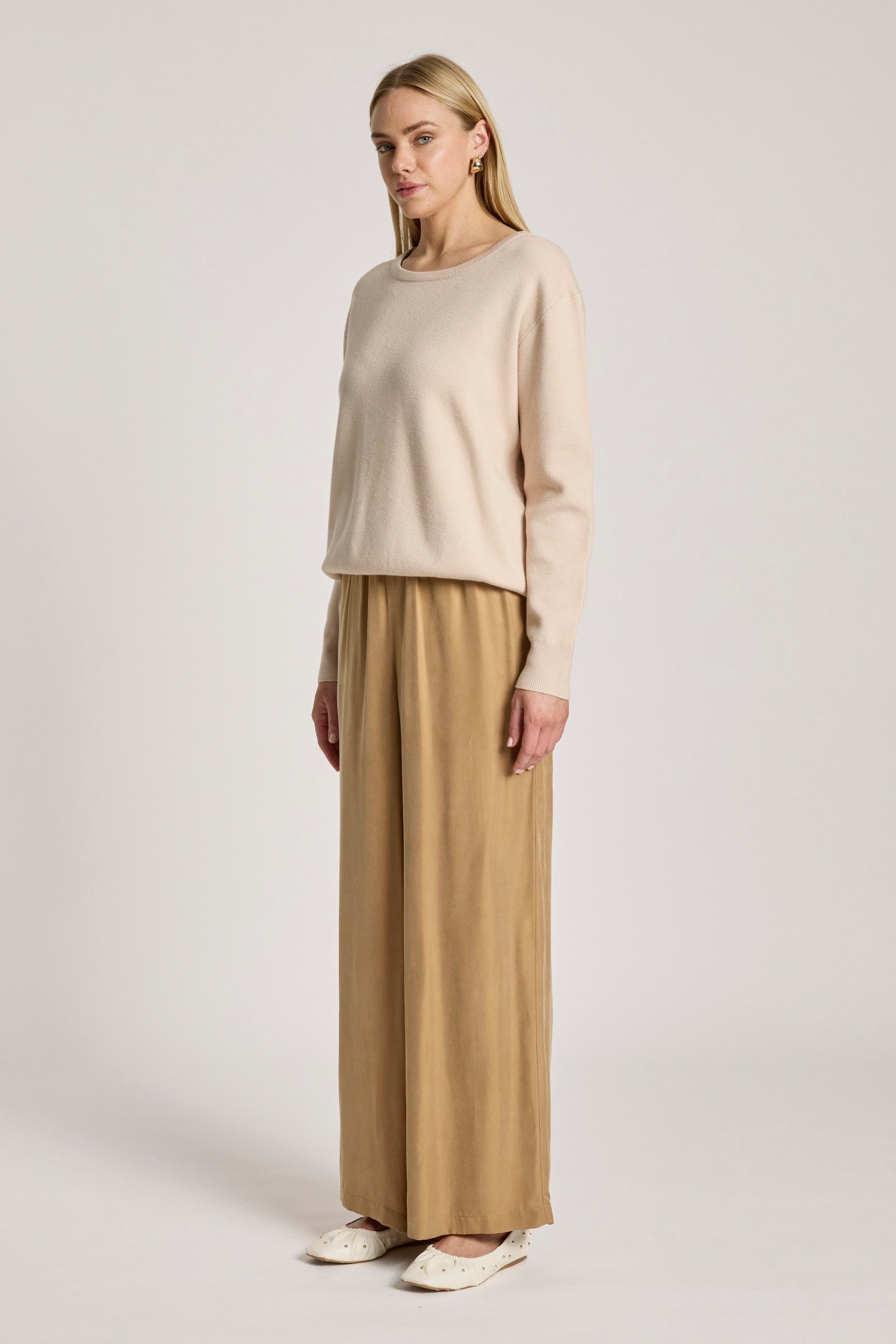 Image of Woman wearing a Eb & Ive beige sweater and tan pants on a white background