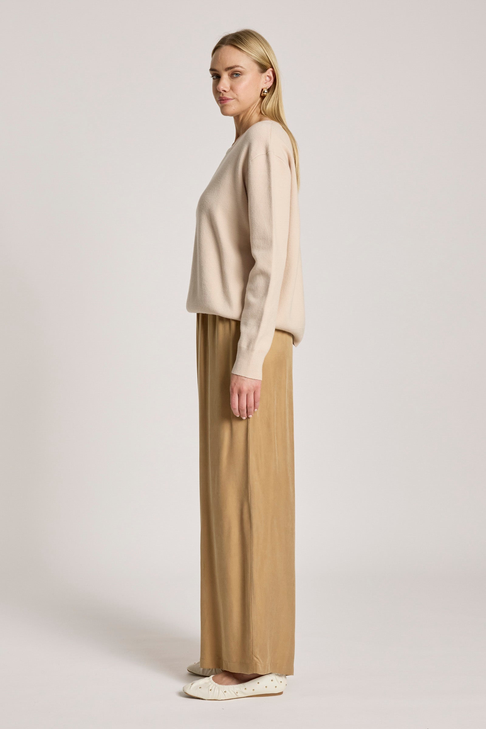 Image of Woman wearing a Eb & Ive beige sweater and tan pants on a white background