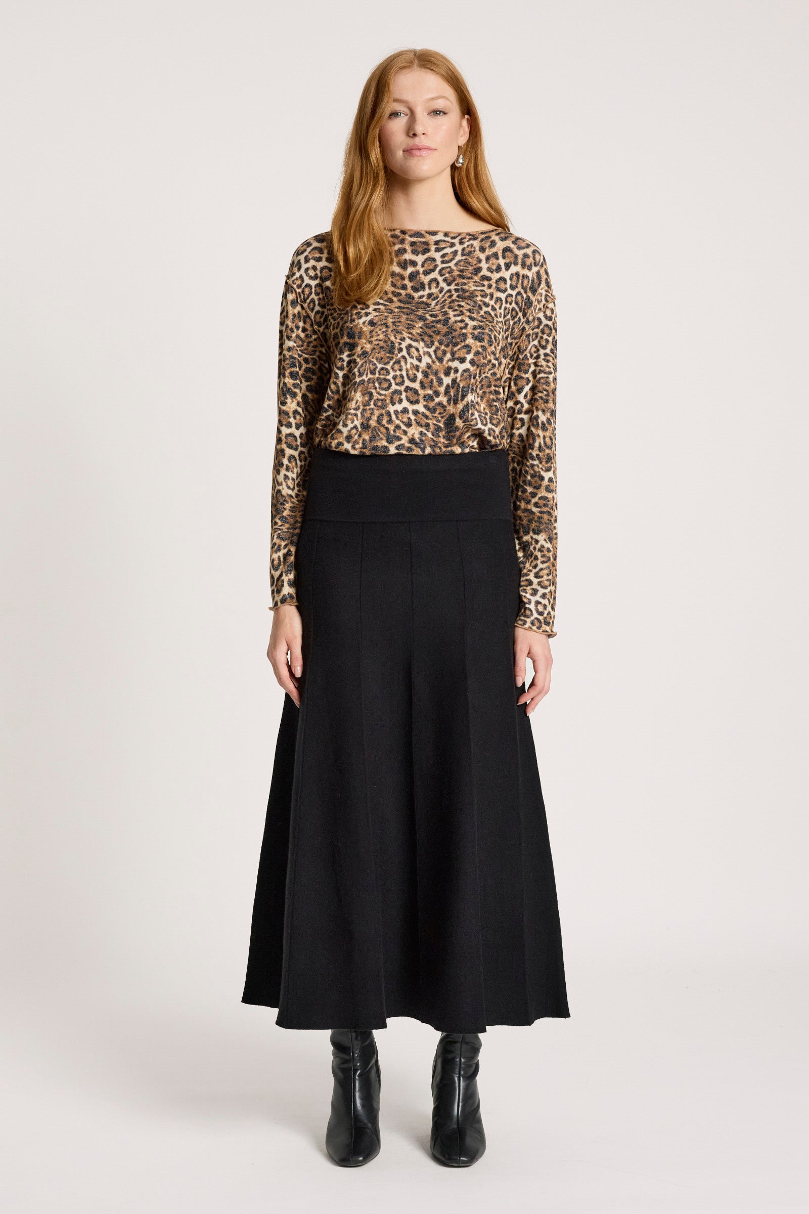 Woman wearing a leopard print top and Eb & Ive black skirt on a white background