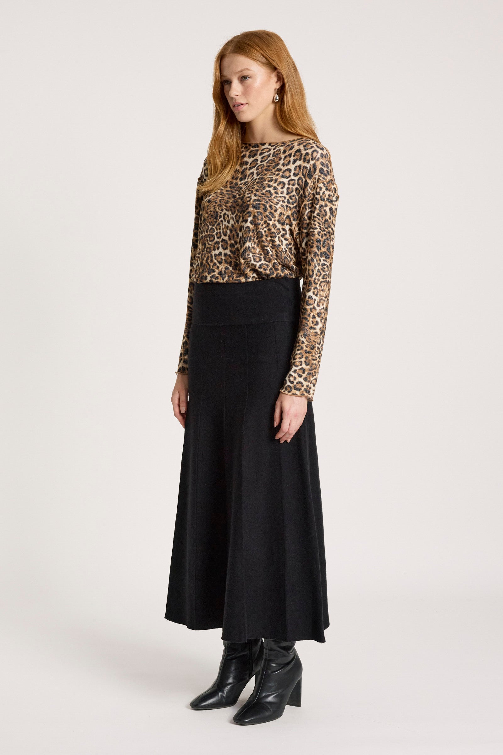Woman wearing a leopard print top and Eb & Ive black skirt on a white background