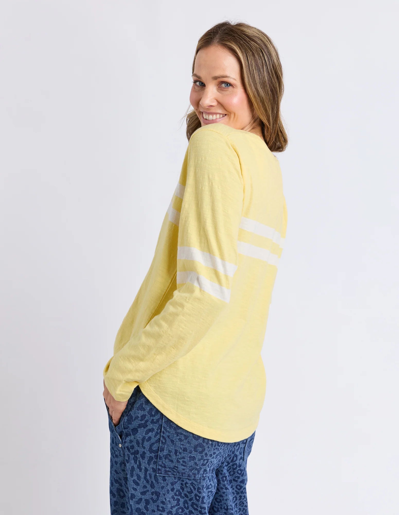 Image of Woman wearing a Elm yellow long-sleeve shirt with white stripes on a plain background