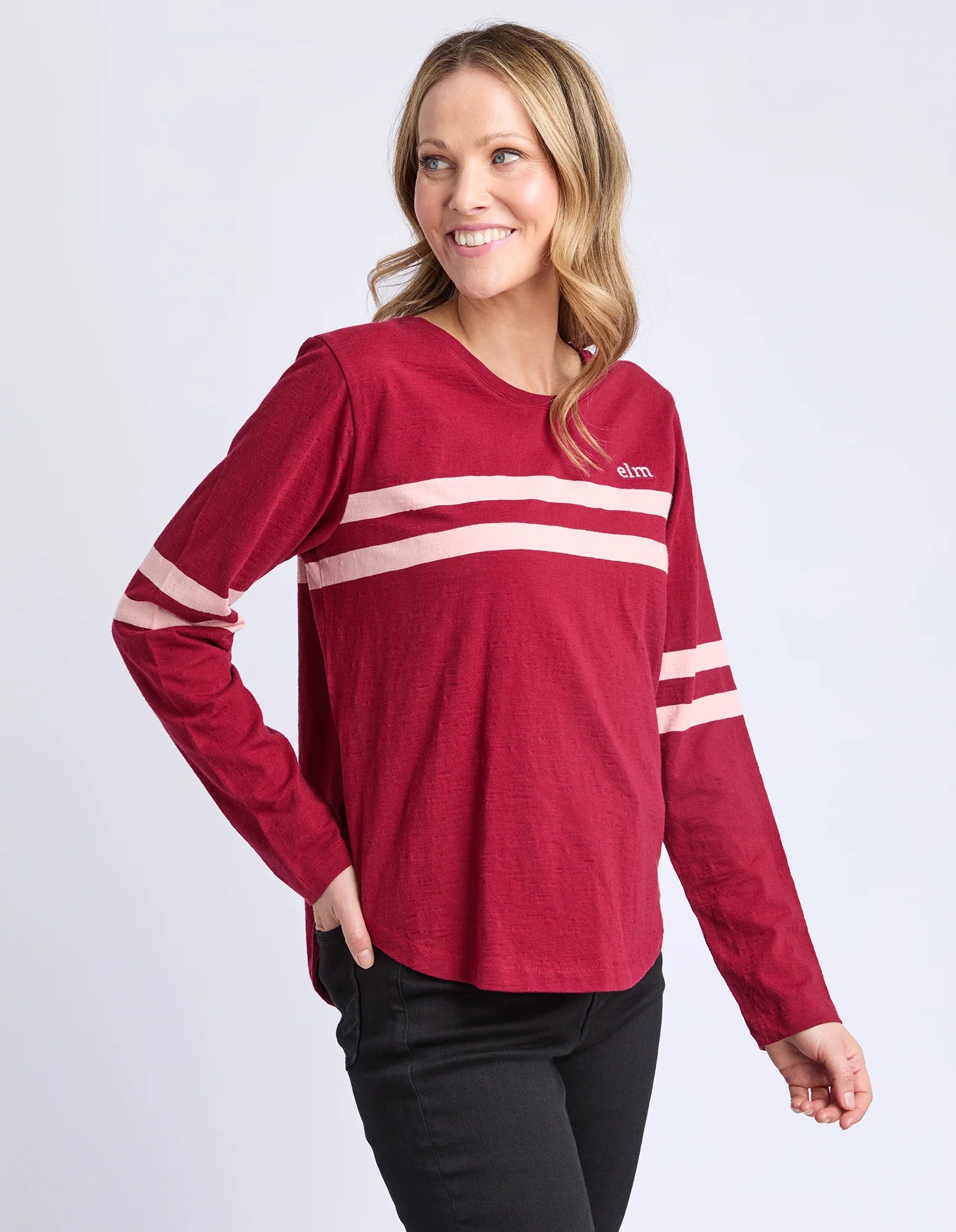 Image of Woman wearing a Elm red long-sleeve shirt with white stripes on a light gray background
