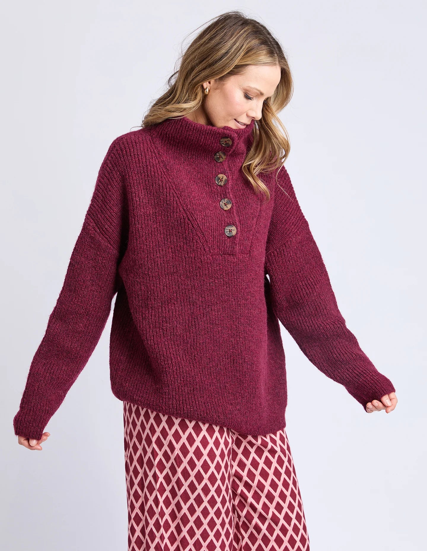 Image of Woman wearing a Elm burgundy knitted sweater on a light gray background