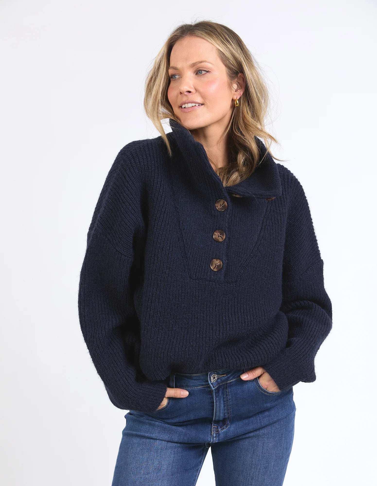 Woman wearing a Elm navy blue knitted sweater with buttons on a white background