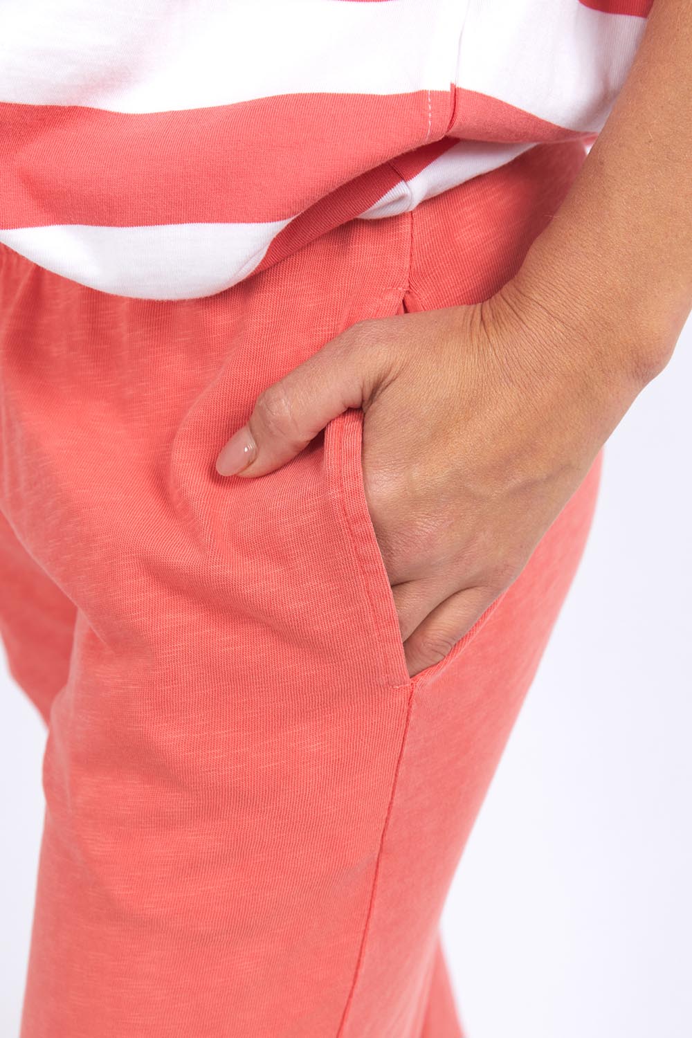 Image of Woman wearing Elm coral pants with a white background