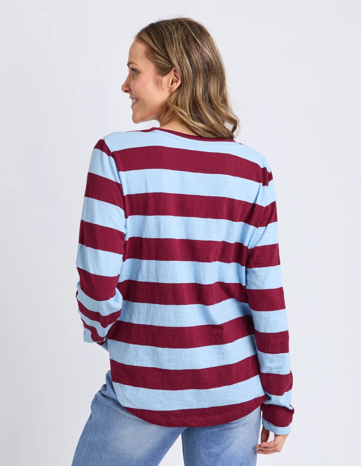 Image of Woman wearing a Elm red and white striped sweater on a plain background