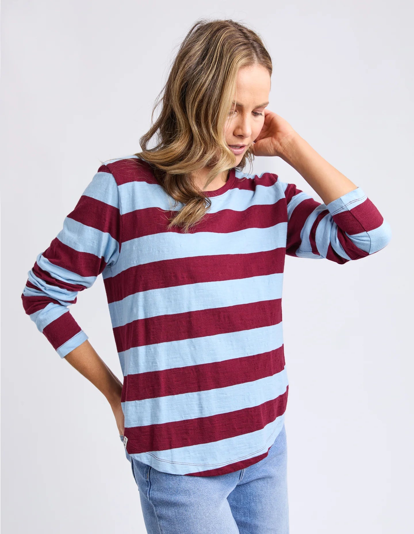 Image of Woman wearing a Elm red and blue striped sweater on a plain background