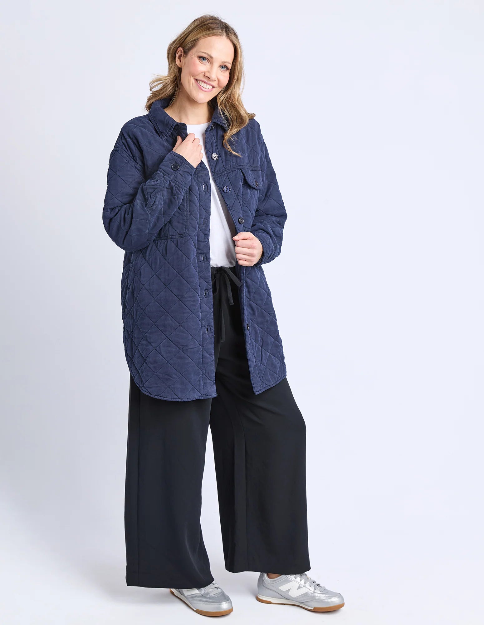 Woman wearing a Elm blue quilted jacket on a white background