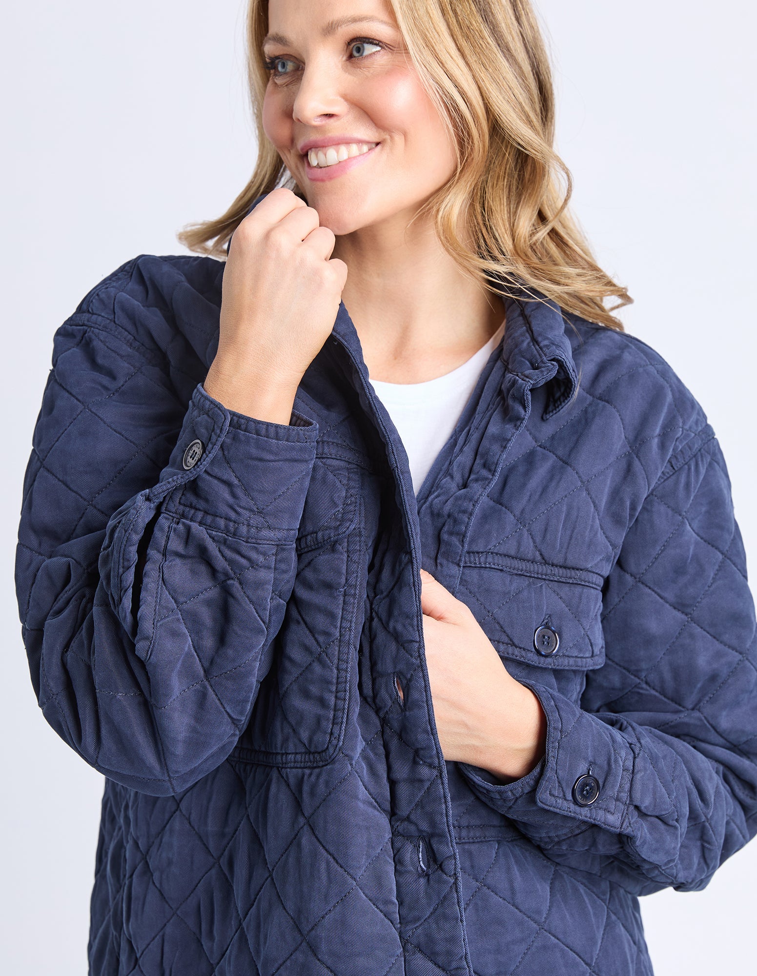 Image of Woman wearing a Elm navy quilted jacket on a white background