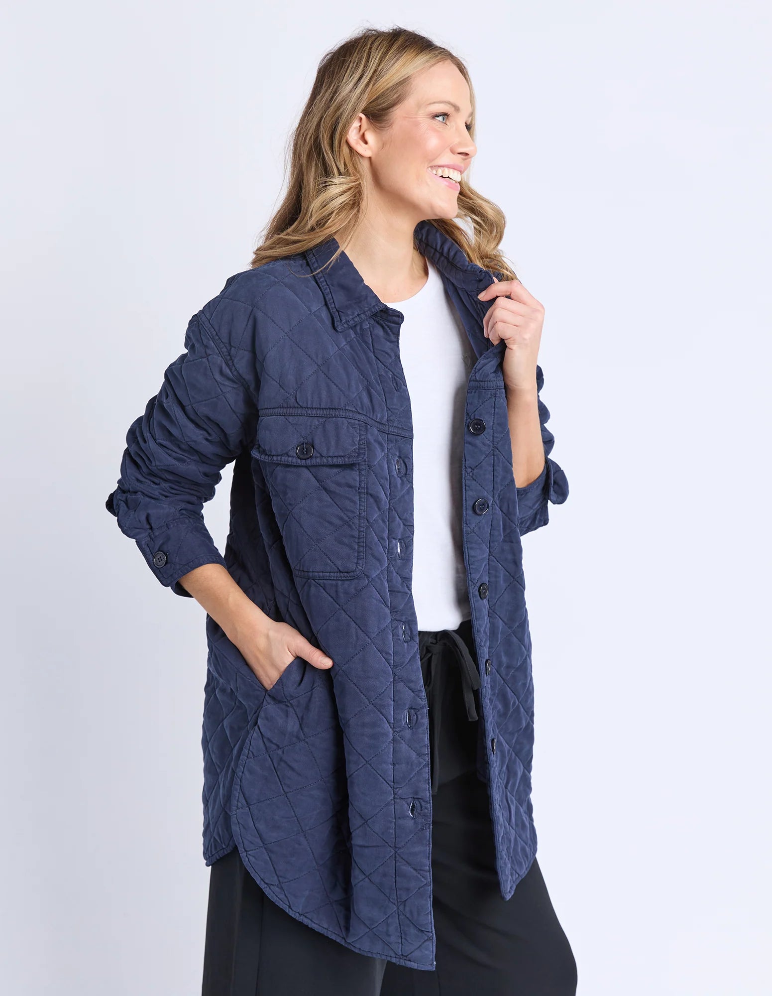 Woman wearing a Elm blue quilted jacket on a white background