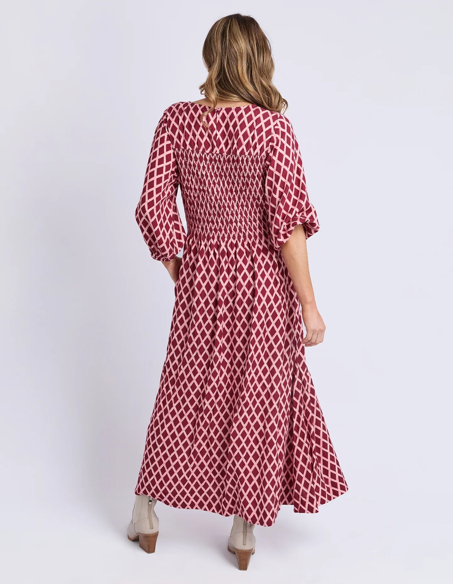 Image of Woman wearing a Elm red patterned dress on a white background