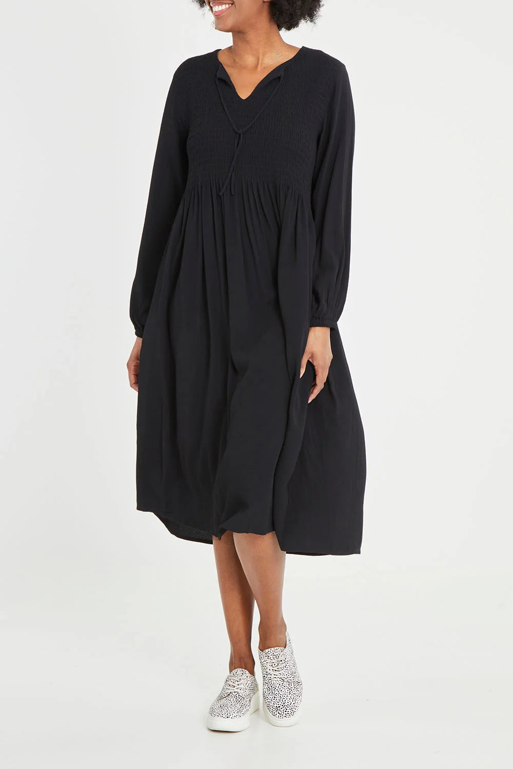Image of Woman wearing a Elm black dress with long sleeves on a white background