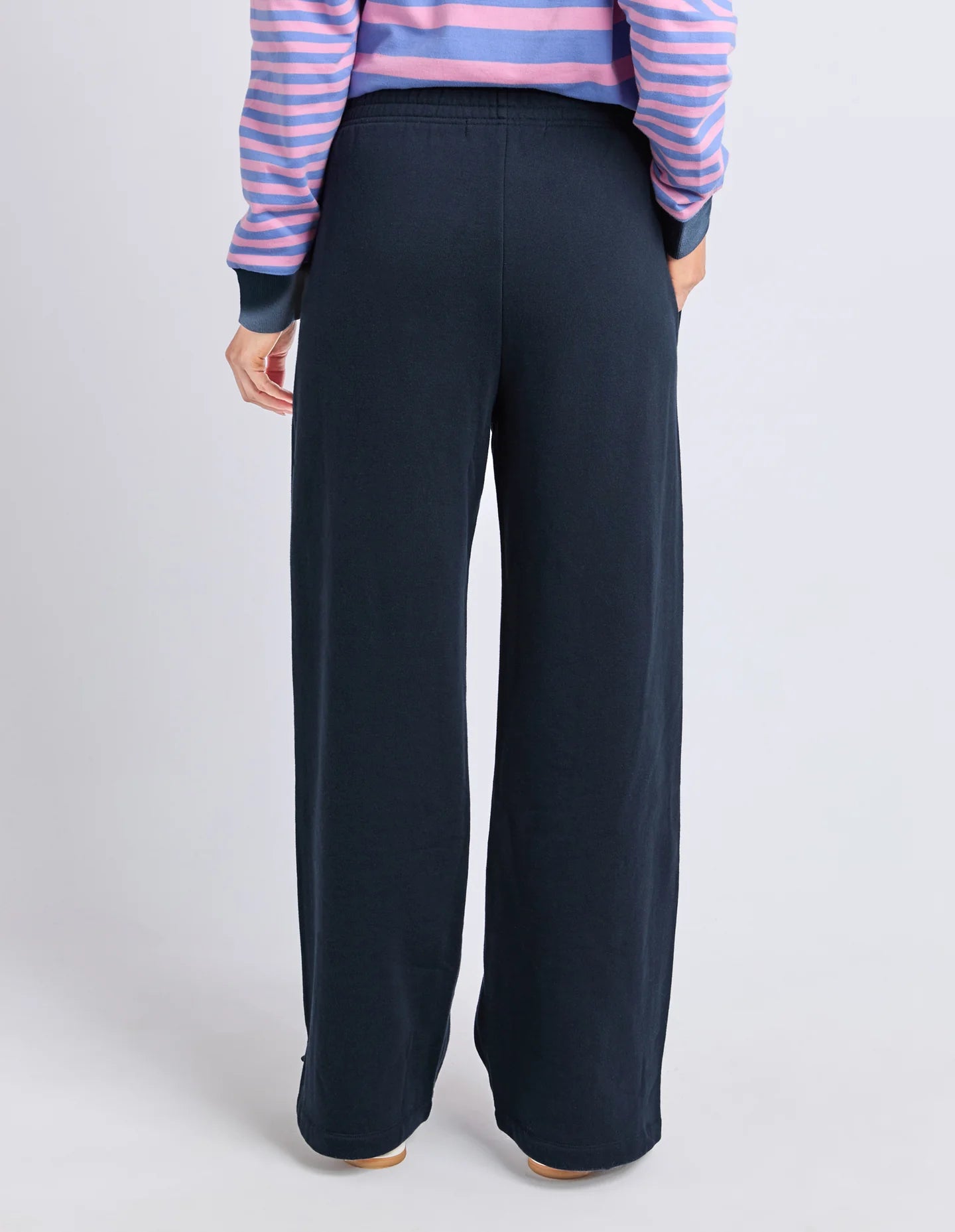 Woman wearing Elm navy wide-leg pants with a striped top on a light gray background
