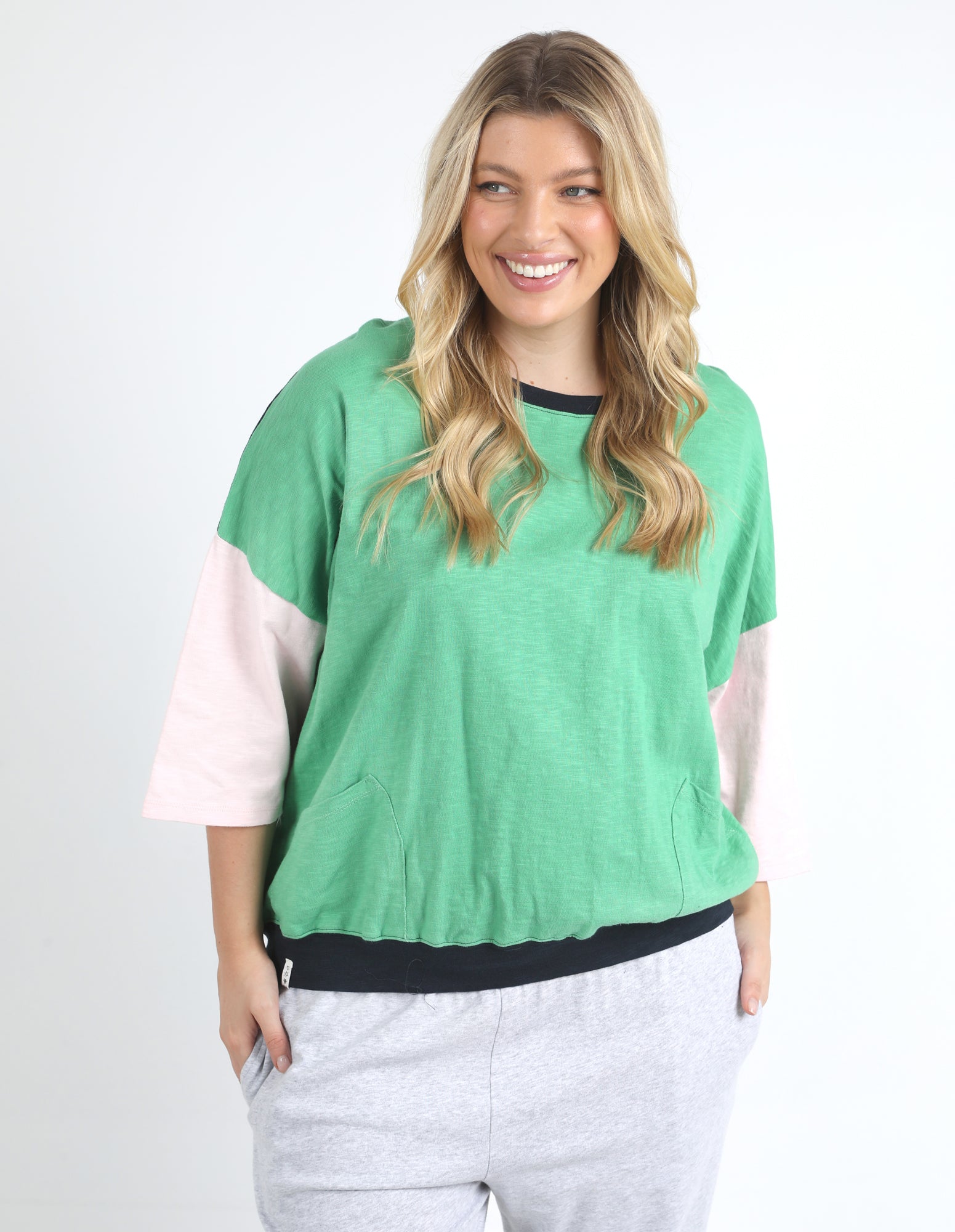 Image of Woman wearing a Elm green and pink color-blocked top on a white background
