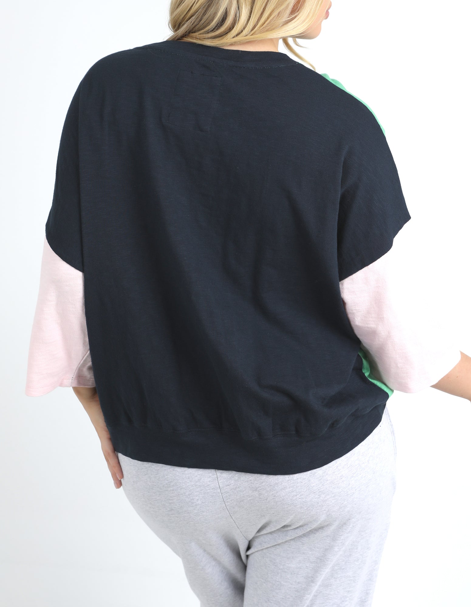 Woman wearing a black and pink top with a white background