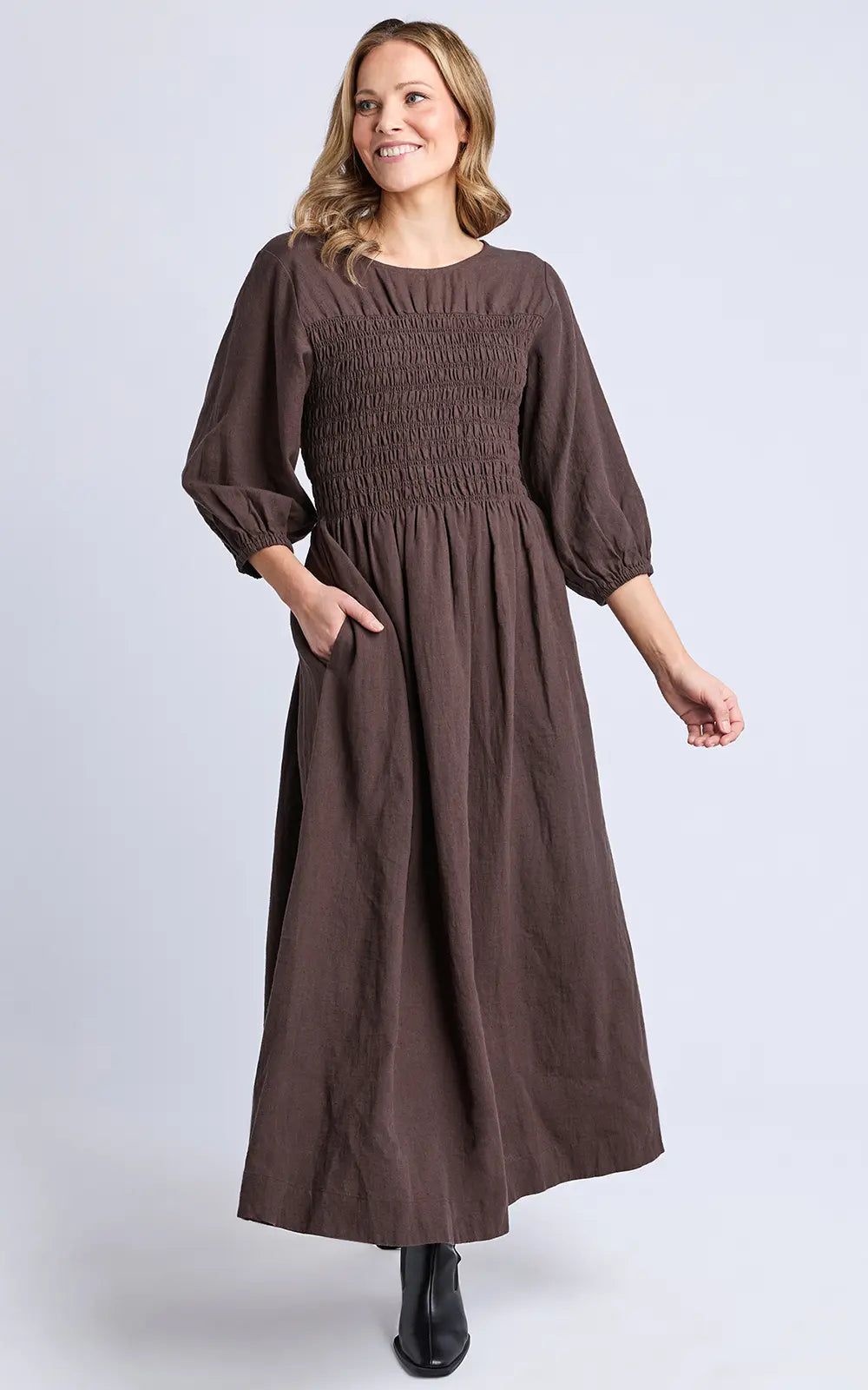 Image of Woman wearing a Elm brown dress against a light gray background