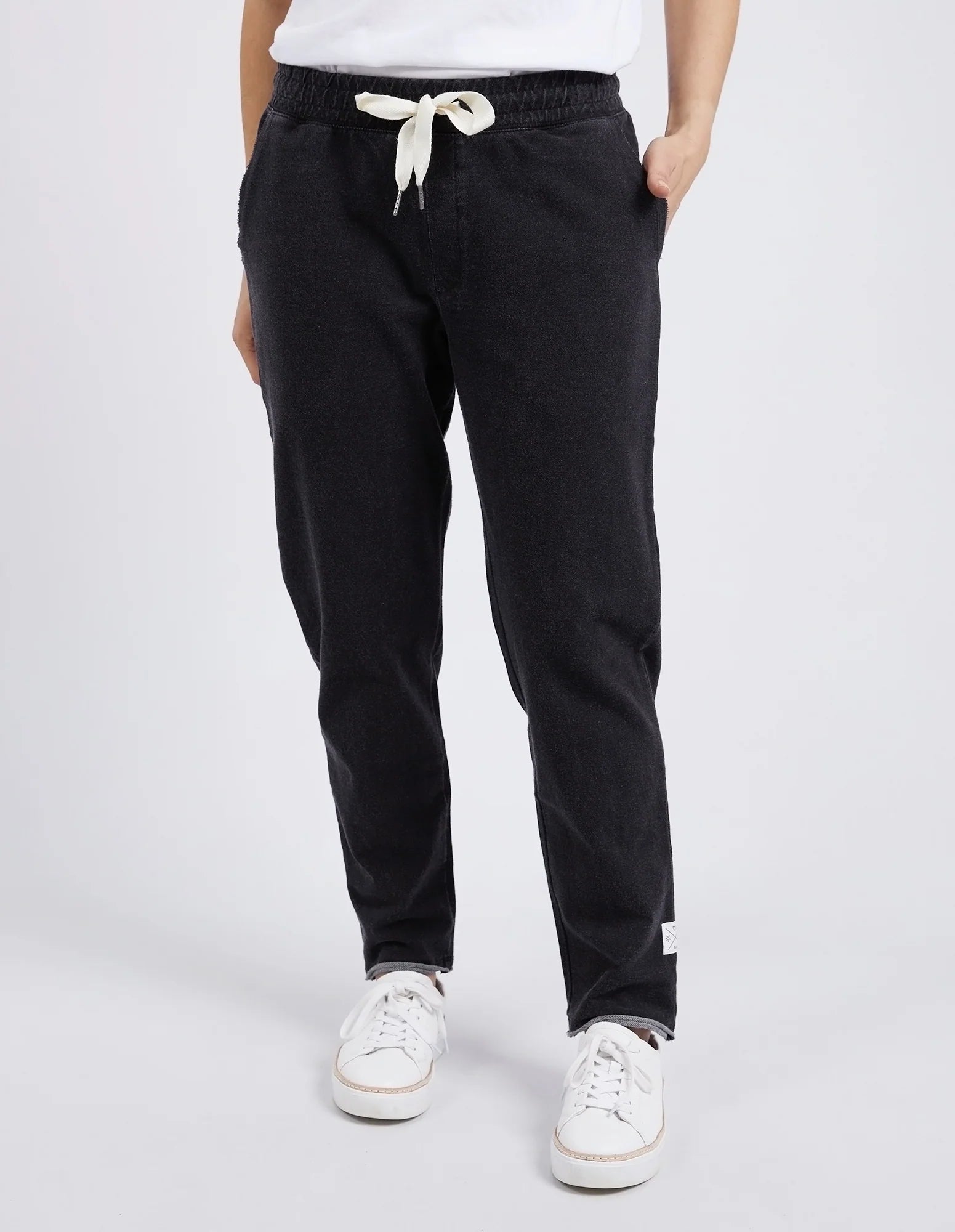 Woman wearing Elm black pants with a white drawstring on a light gray background