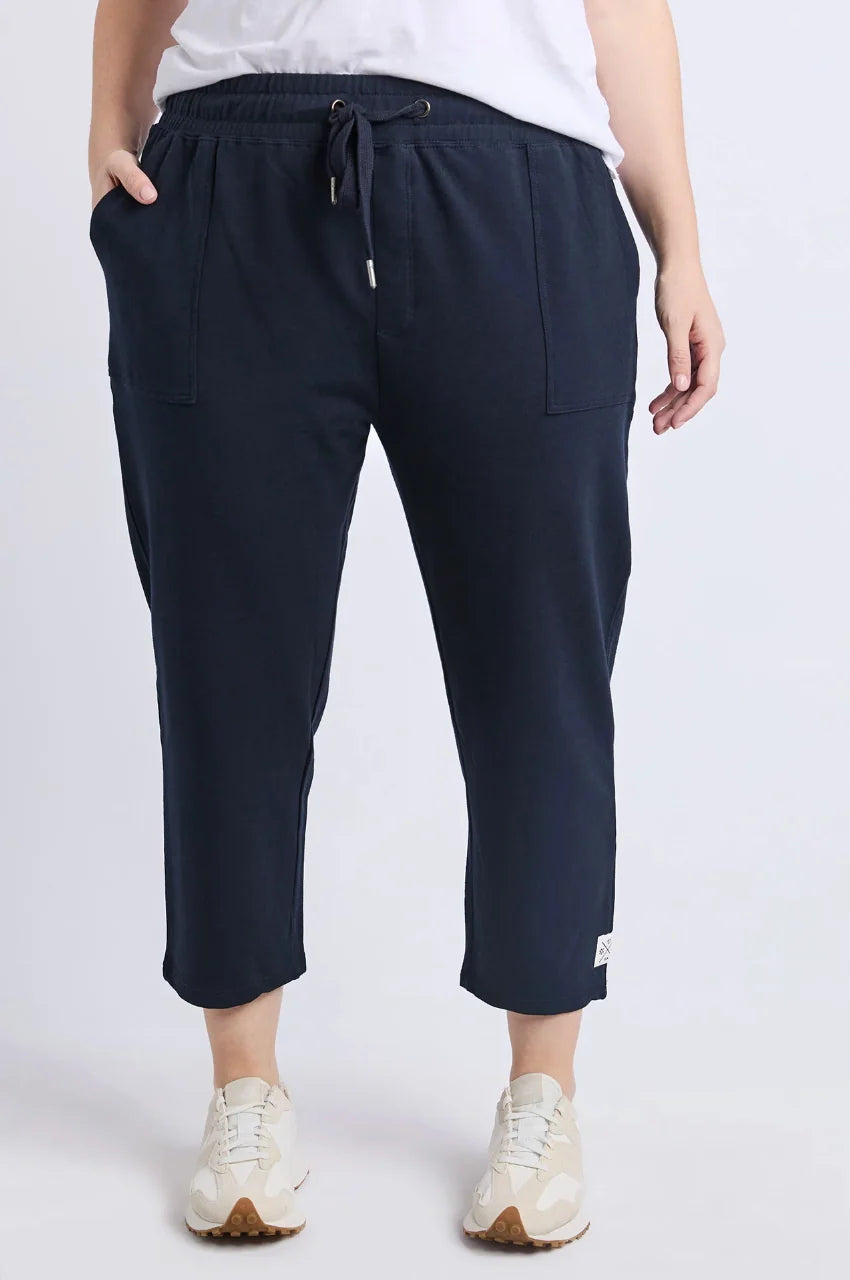 Woman wearing Elm navy blue pants with a white background