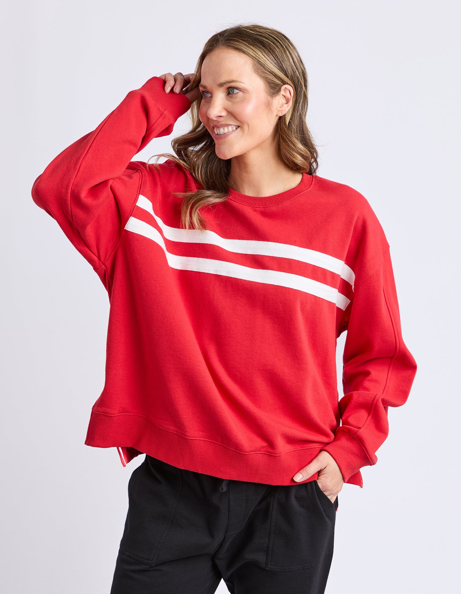 Person wearing a red jumper with a white stripe on a light grey background
