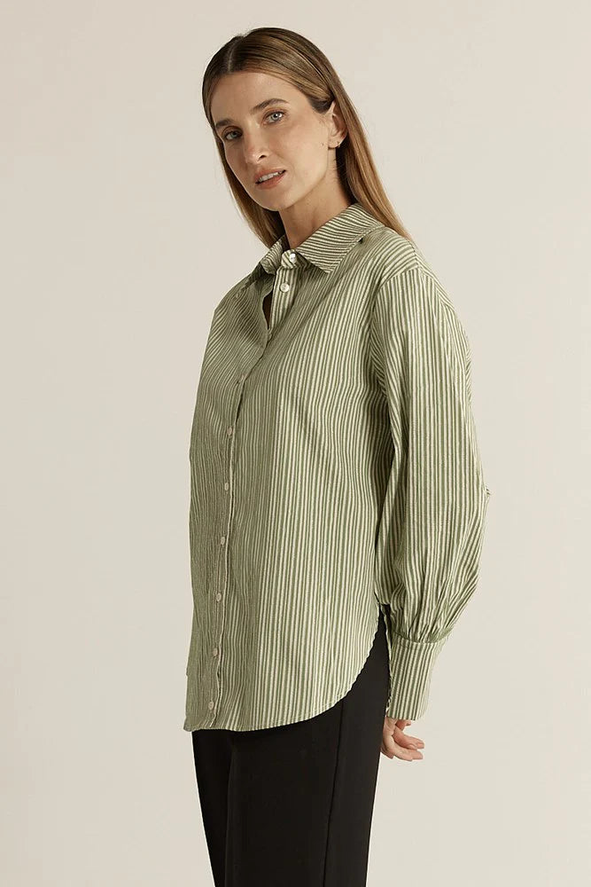 Image of Woman wearing a Fate & Becker green striped shirt against a beige background