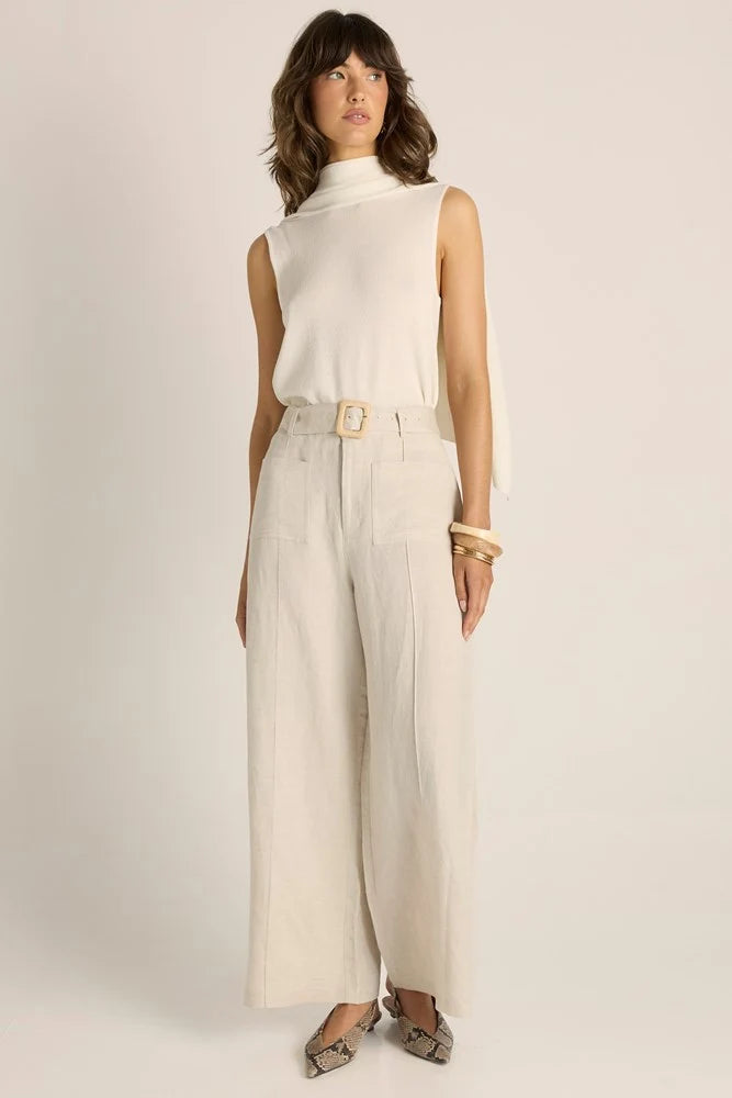 Woman wearing a Fate & Becker beige sleeveless top and wide-leg pants on a plain background
