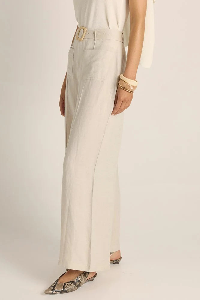 Woman wearing Fate & Becker light-colored pants with a belt on a plain background