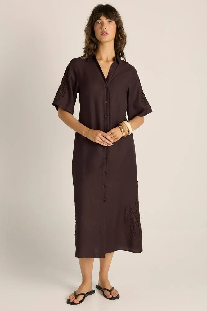 Woman wearing a Fate & Becker brown dress against a plain background